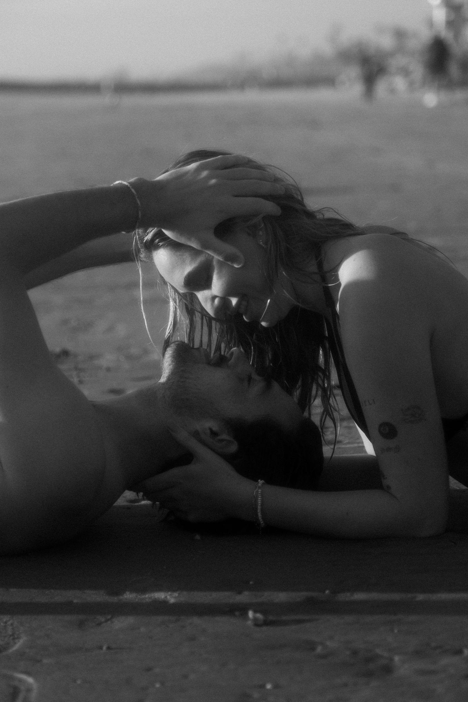 A series of black and white artistic photos showing a person lying down across multiple frames.