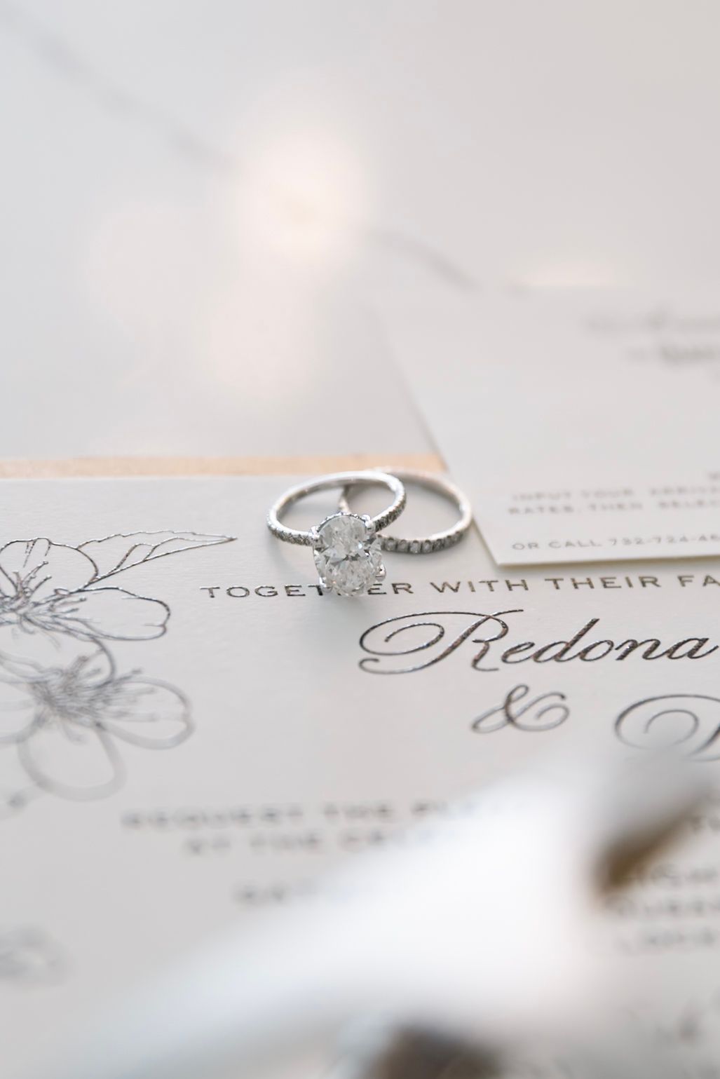 Close-up shots of an elegant wedding invitation with engagement ring details.