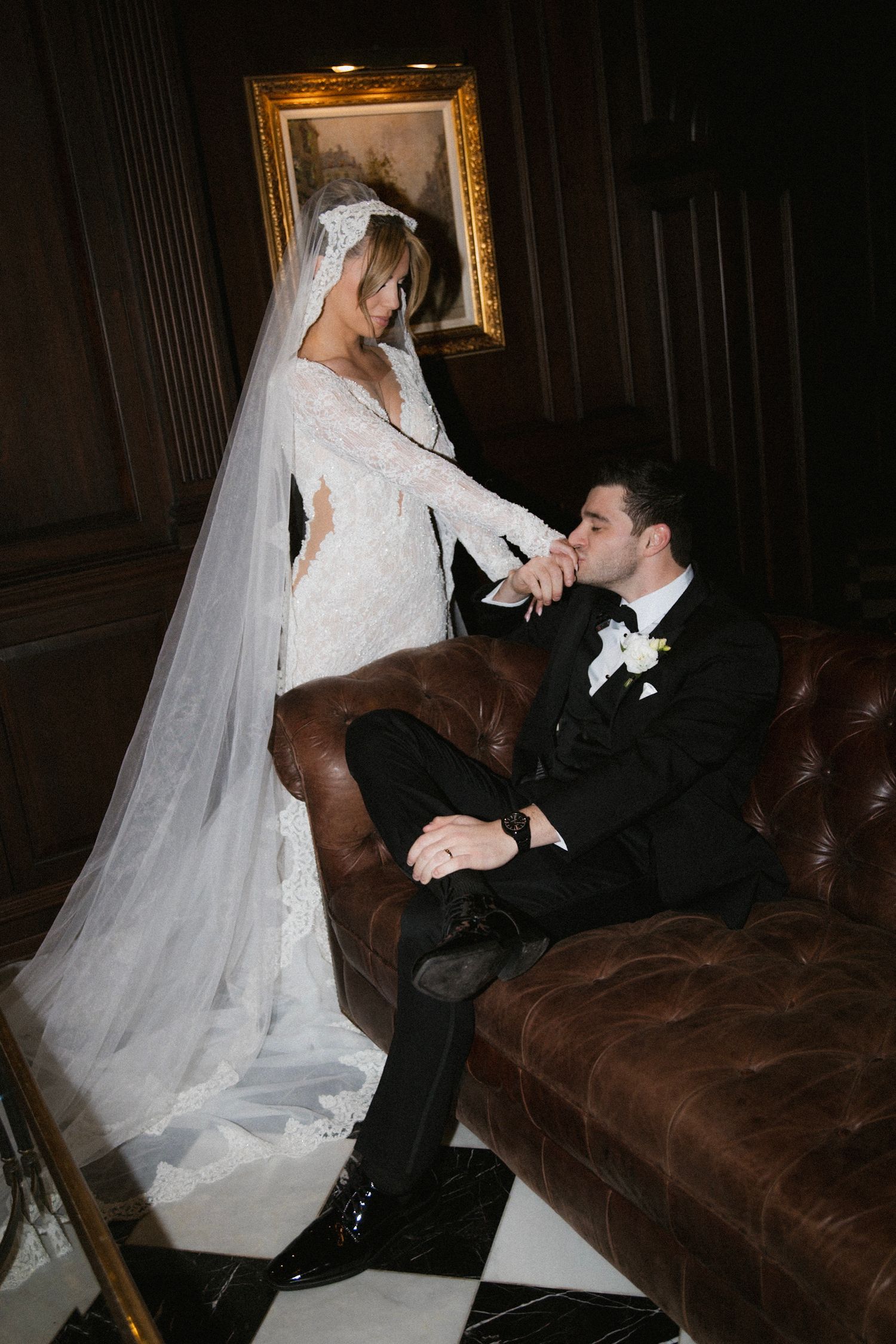 Five sequential romantic wedding photos show a couple on a leather couch in elegant attire during an indoor photoshoot.