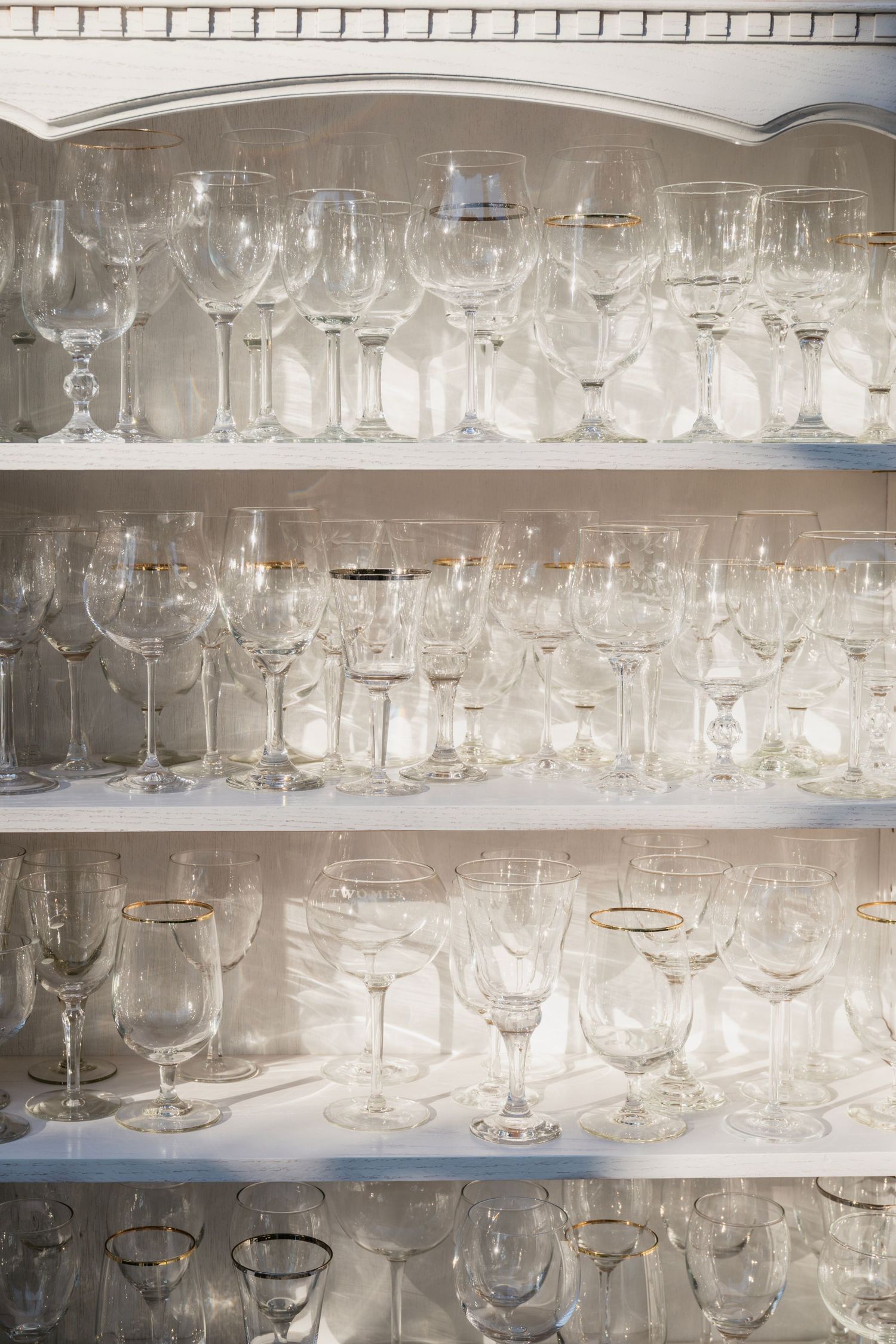 Multiple rows of crystal glassware displayed on shelves.