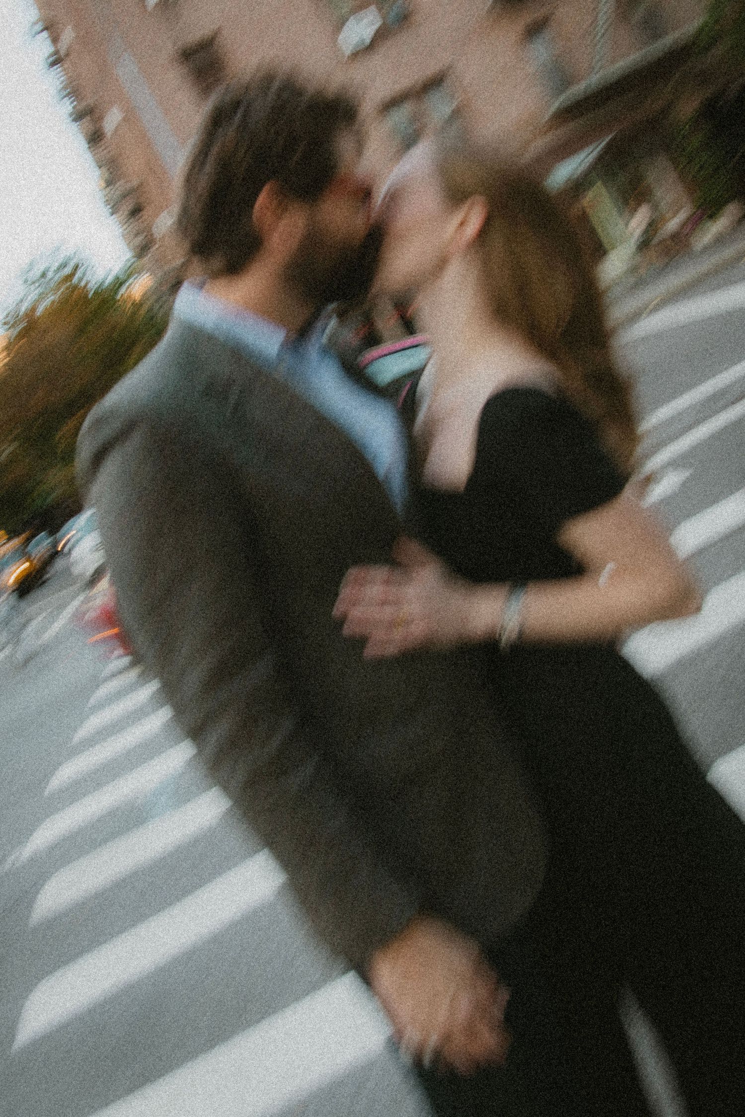 Motion-blurred sequence of a couple sharing a romantic moment on a city street.