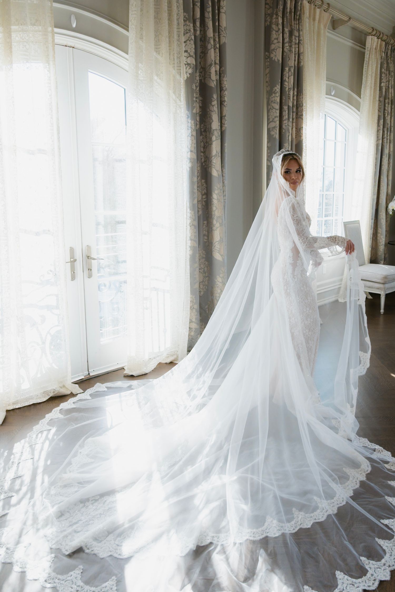 Ethereal bridal portrait with flowing white wedding gown and cathedral veil captured in sequence against sunlit windows.