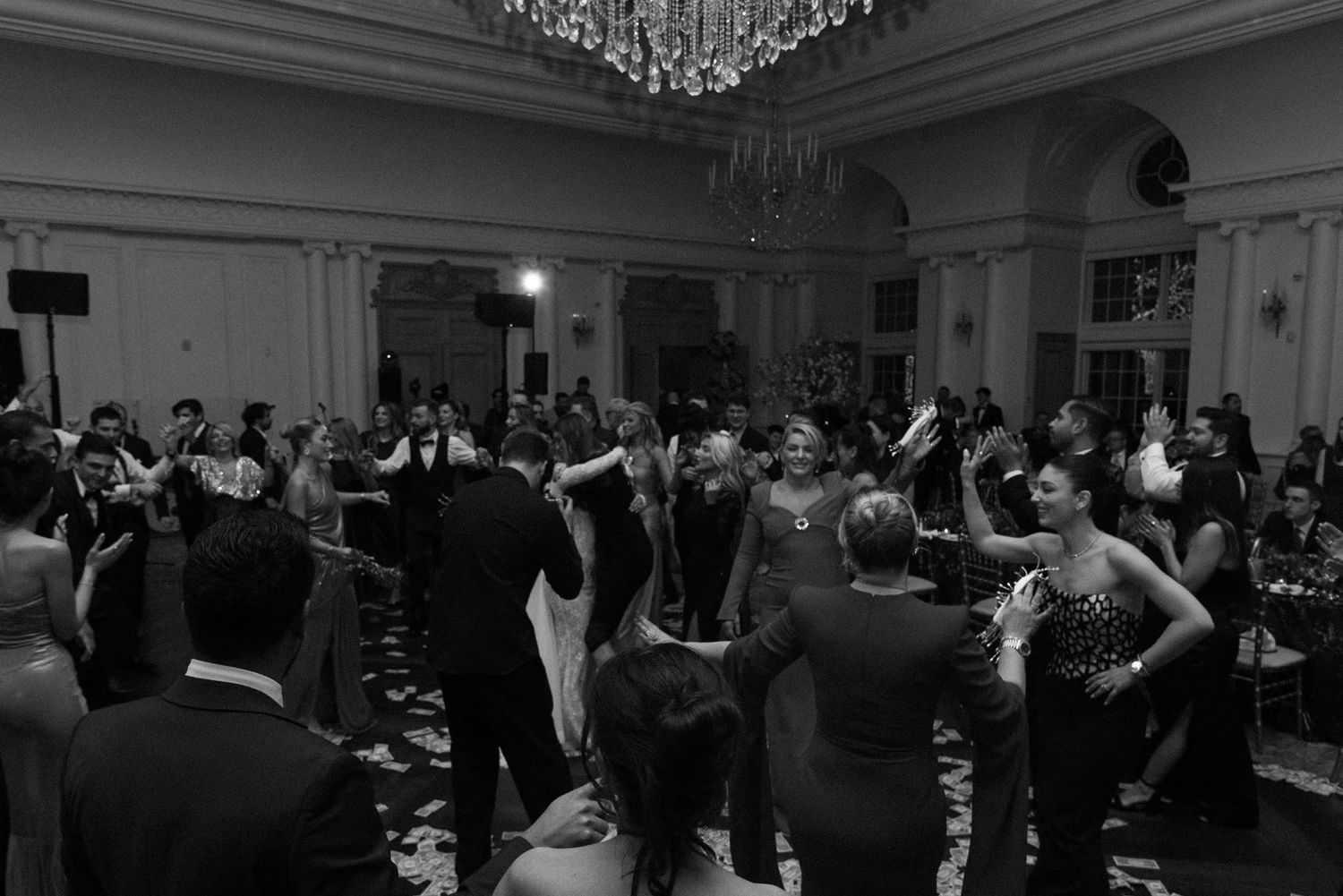 Black and white photo of wedding reception dancing in an elegant ballroom.