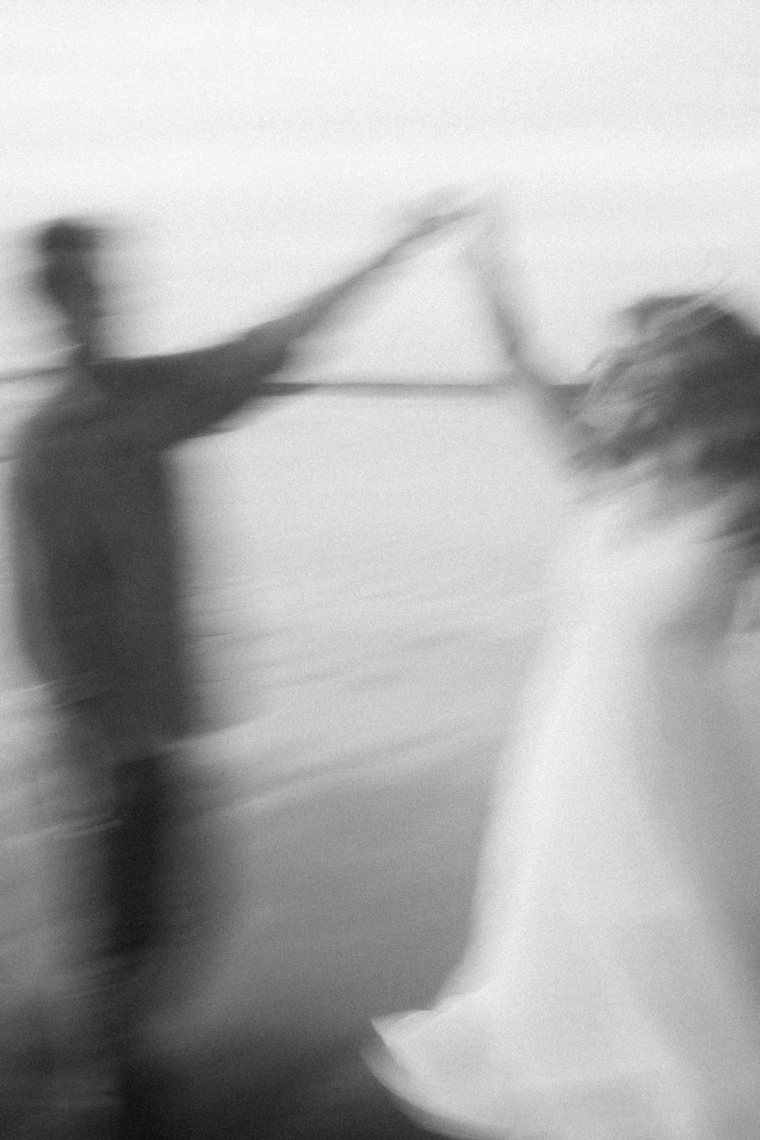 Blurred silhouettes dance together against a bright background.