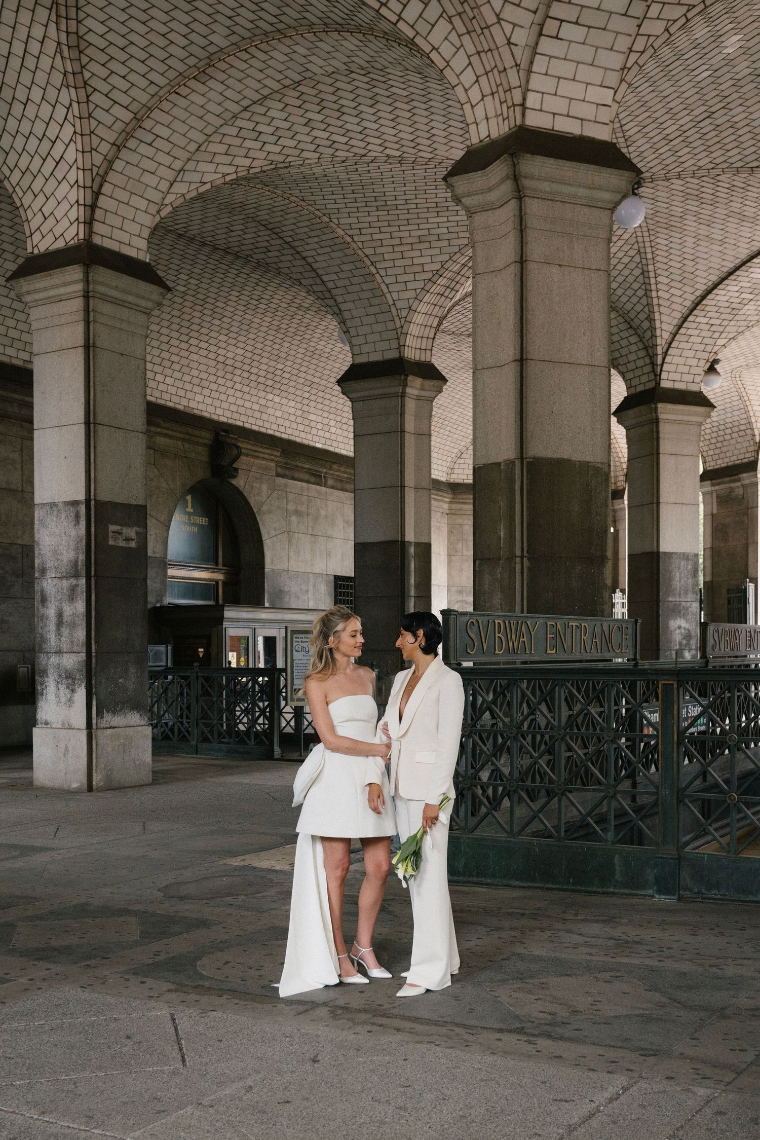 Couple dancing together under the vaulted brick ceilings of a historic building's basement or crypt area.