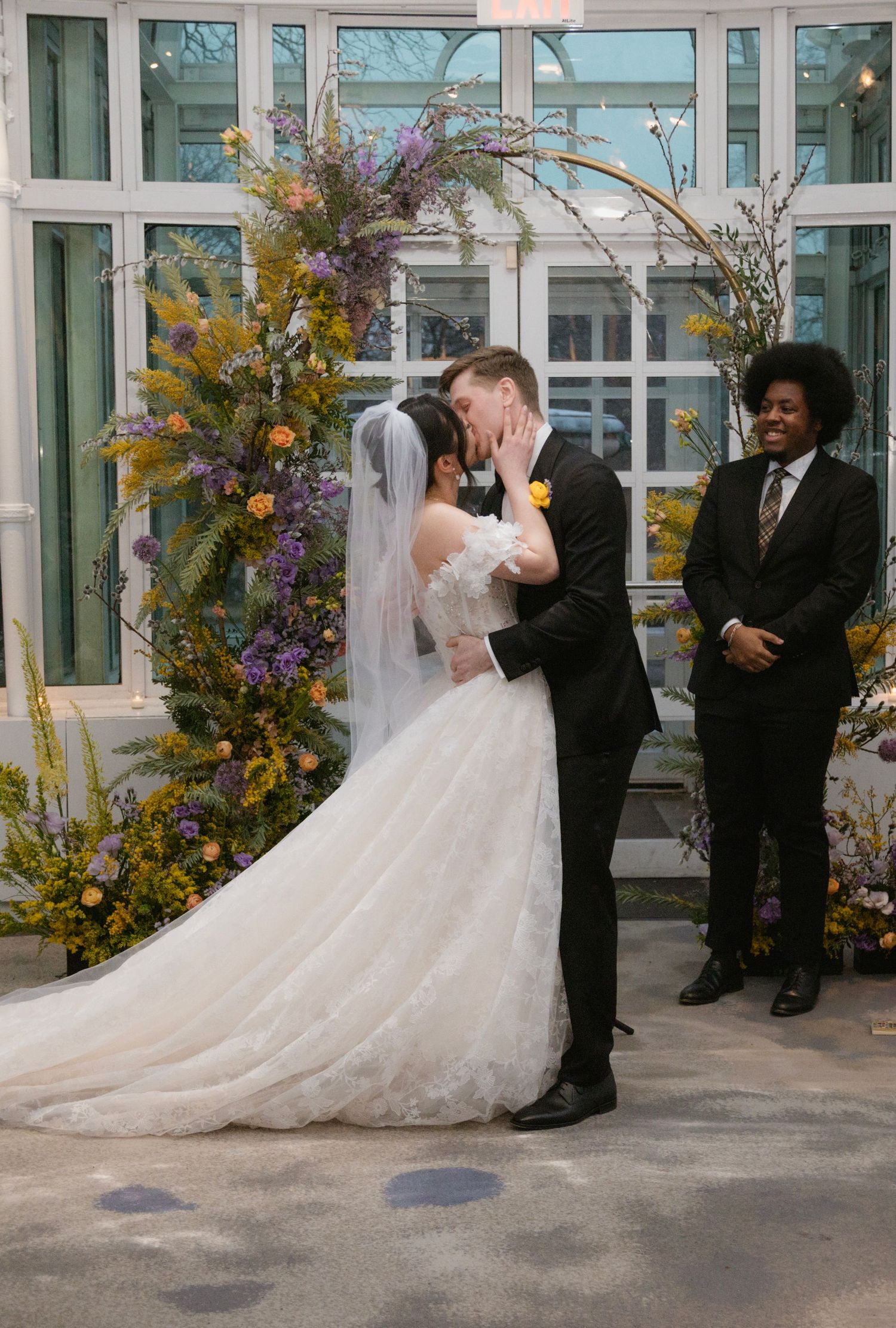 Wedding ceremony moments captured in a bright glass conservatory with autumn floral decorations.
