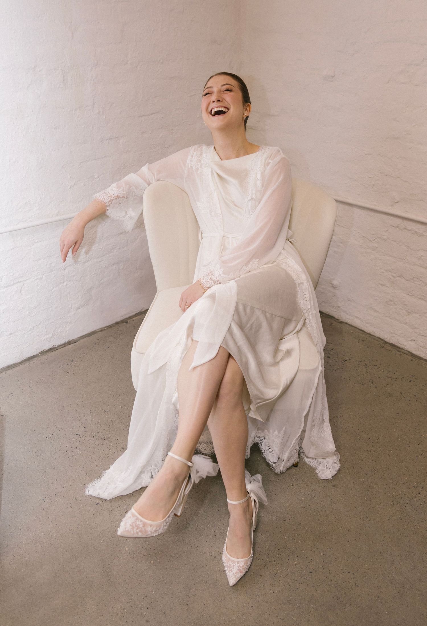Candid moment of joy captured in white bridal preparation room.