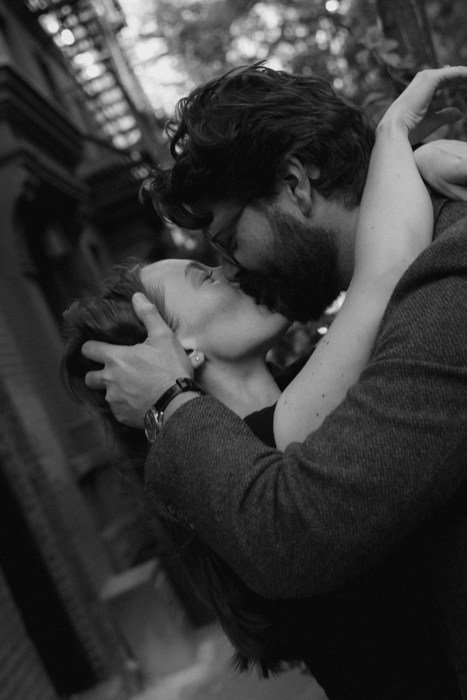 A romantic black and white photograph captures an intimate embrace between two people sharing a passionate moment.