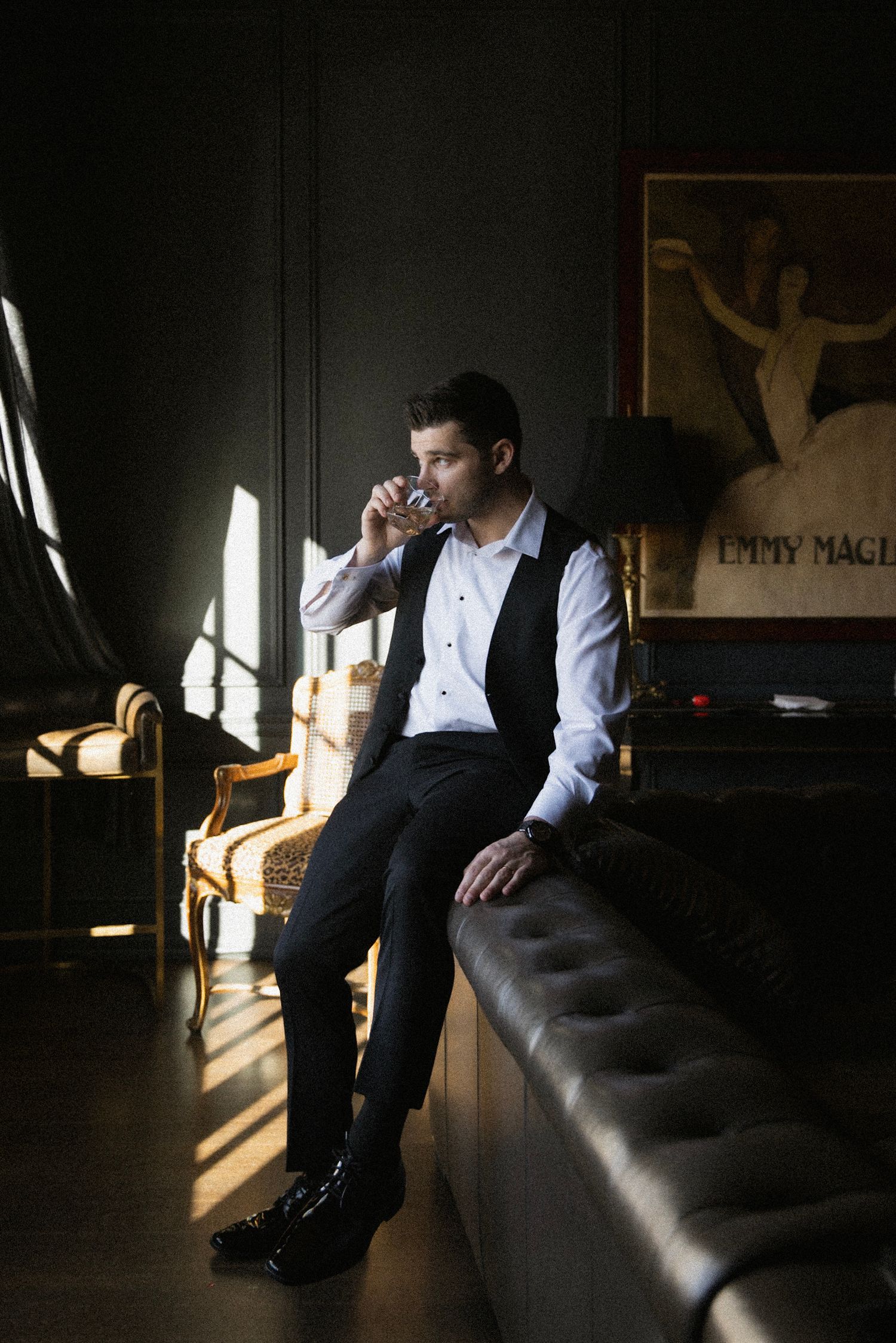 Moody sequence of sunlit room interior with person sitting in dark formal attire creating dramatic shadows.