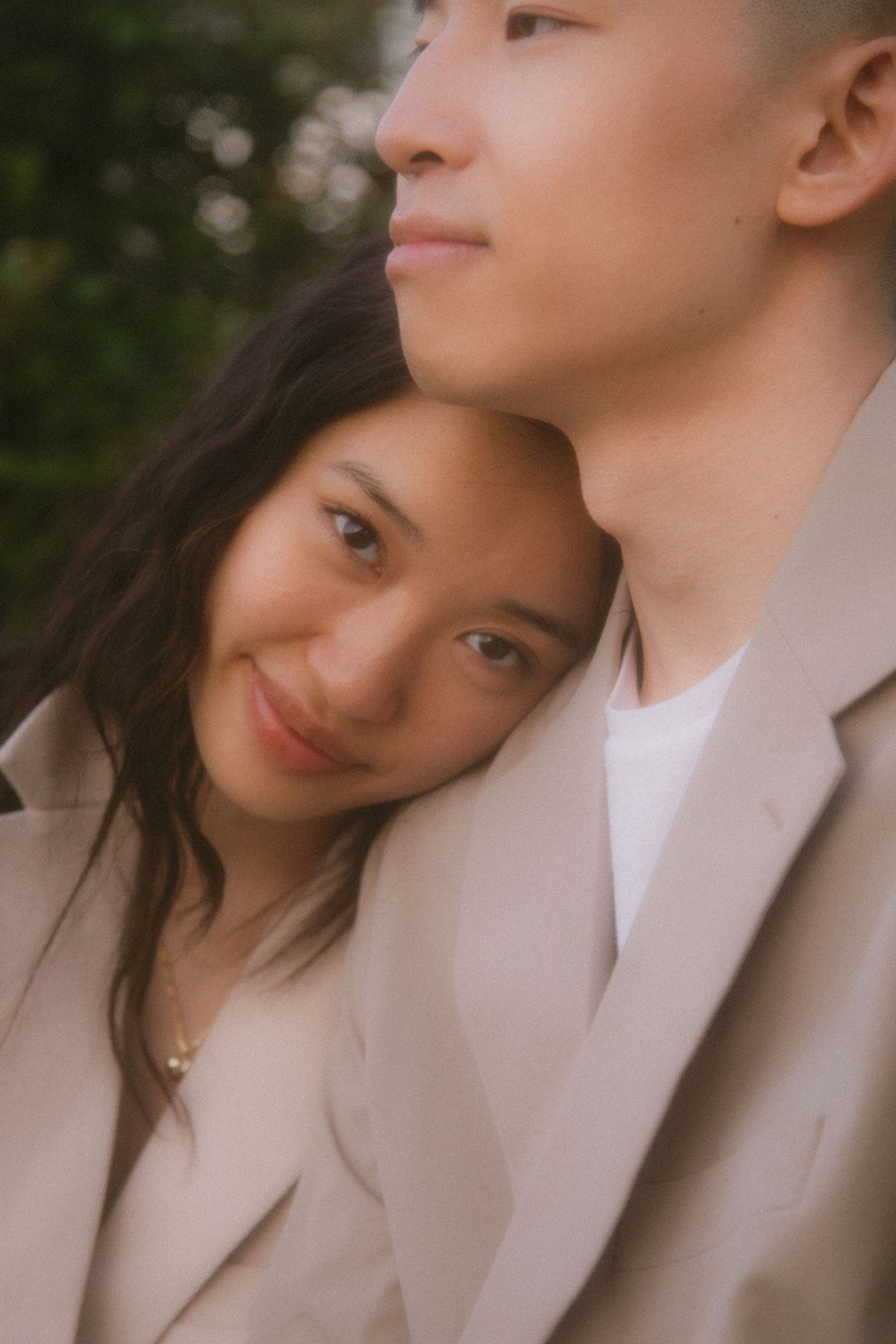 Romantic close-up portrait shot of couple in matching beige outfits.