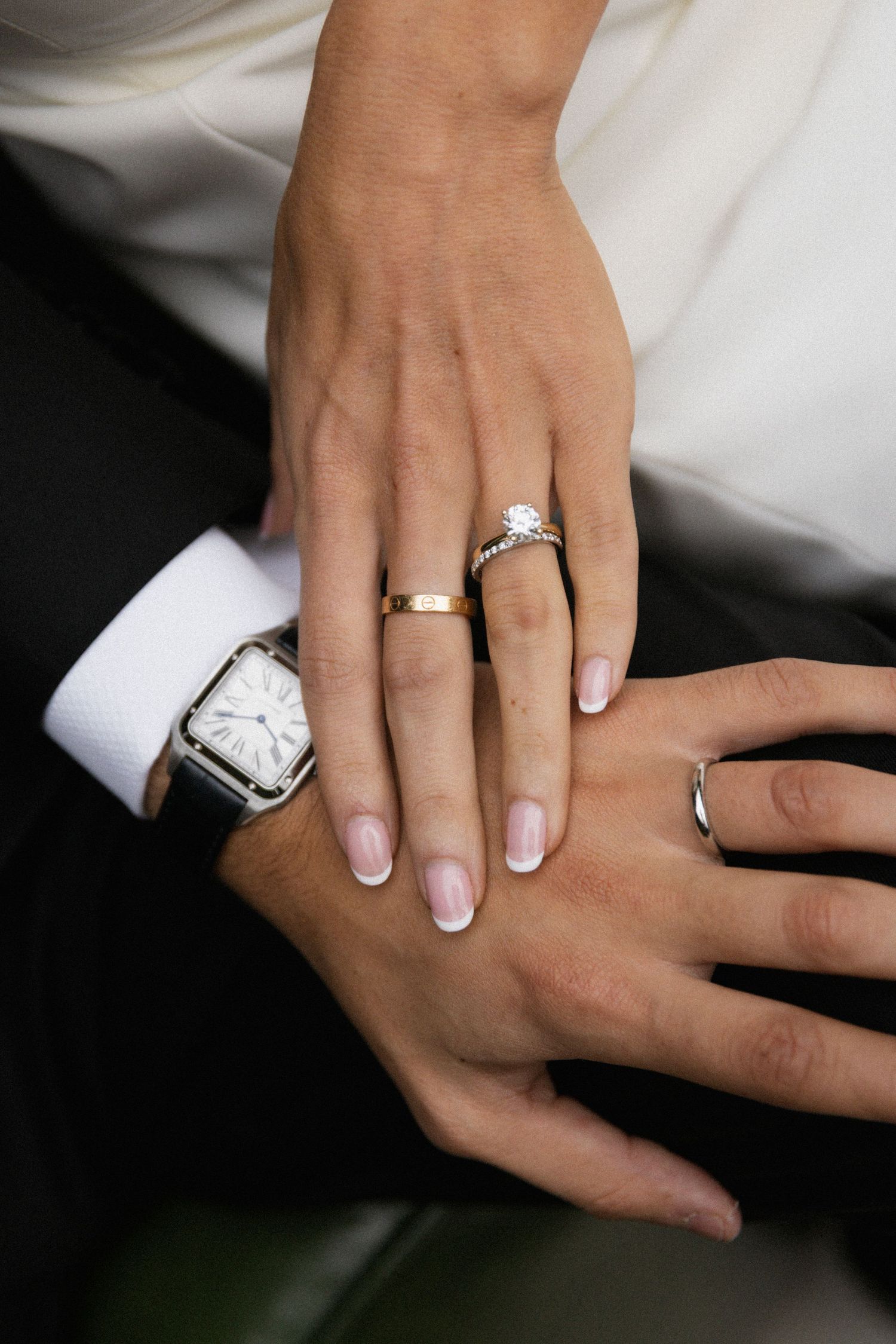 Close-up series of hands wearing wedding rings and engagement rings with manicured nails against white and dark backgrounds.