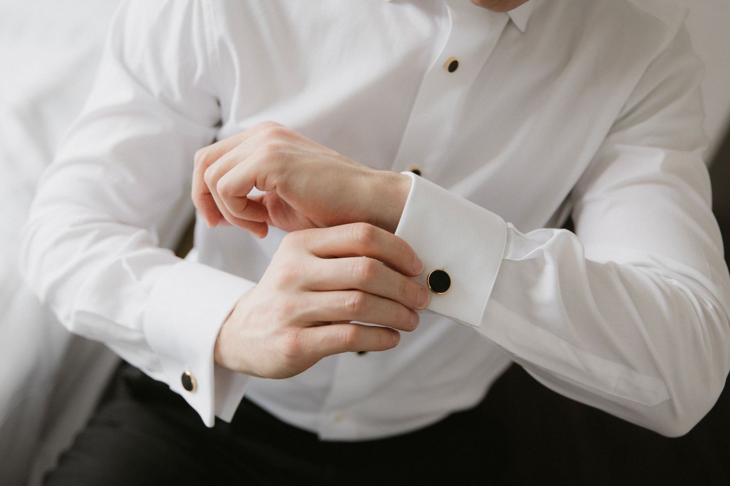 Close-up shots of adjusting dress shirt buttons and cuffs.