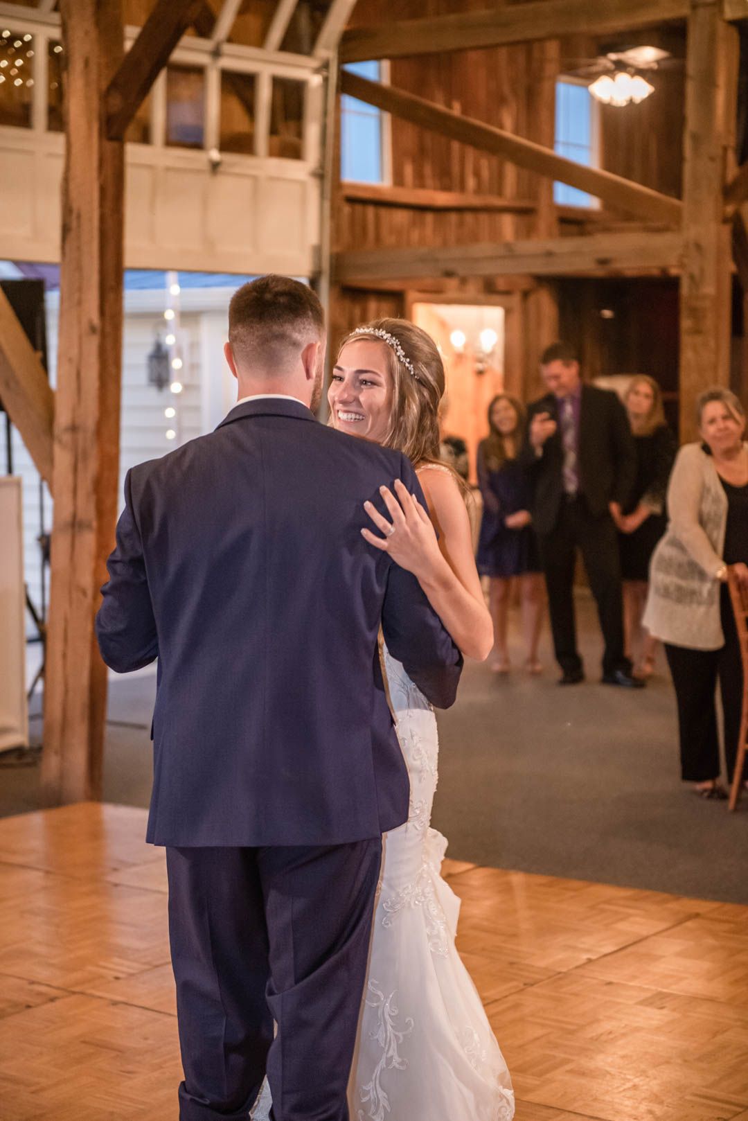 Bride and groom share their first dance in a rustic barn wedding reception venue.