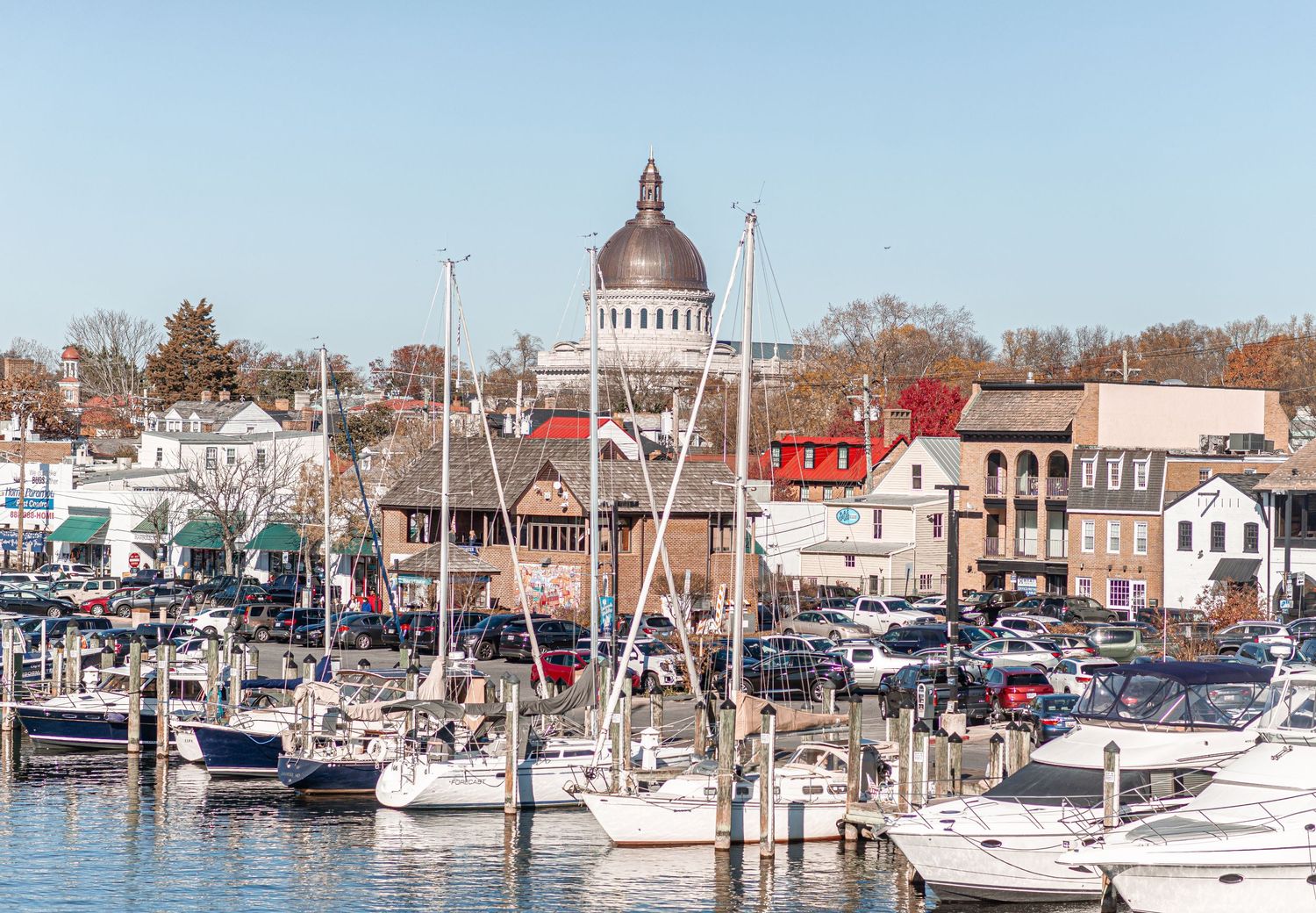 Scenic harbor view of Annapolis Maryland with sailboats and historic domed building on a clear day.