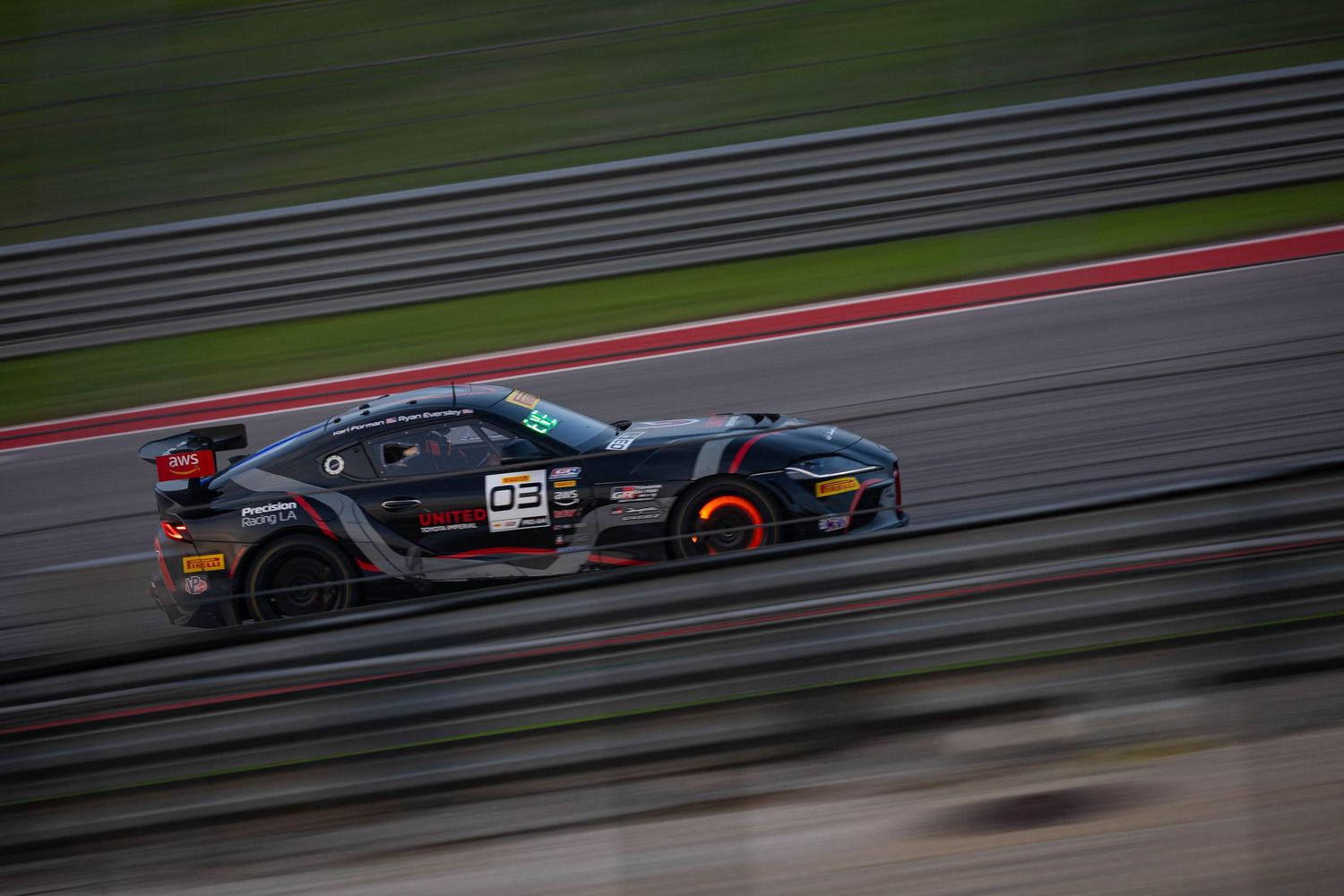 Black number 93 GT racing car captured in motion blur while cornering at speed on a motorsport circuit.
