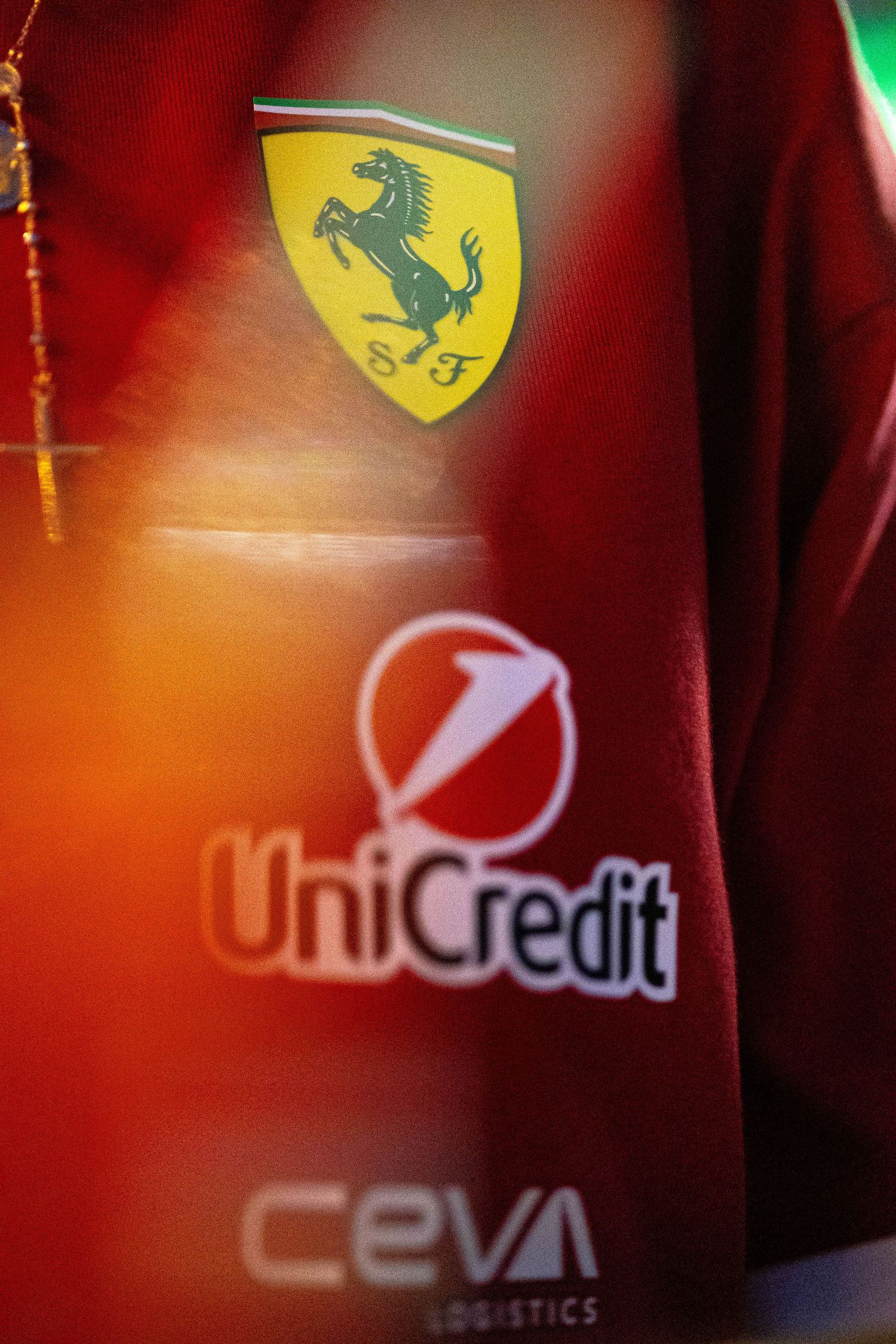 Ferrari Scuderia team uniform displaying UniCredit and CEVA Logistics sponsor logos up close.
