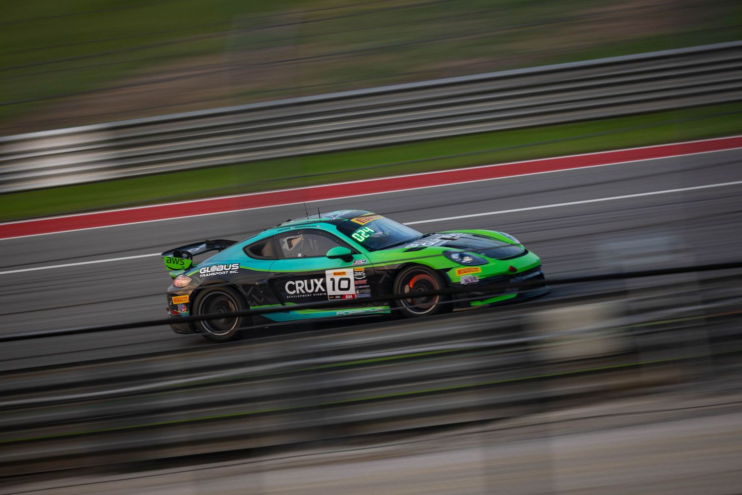 Black Lamborghini GT3 No.99 race car captured with motion blur speeding along a racing circuit.