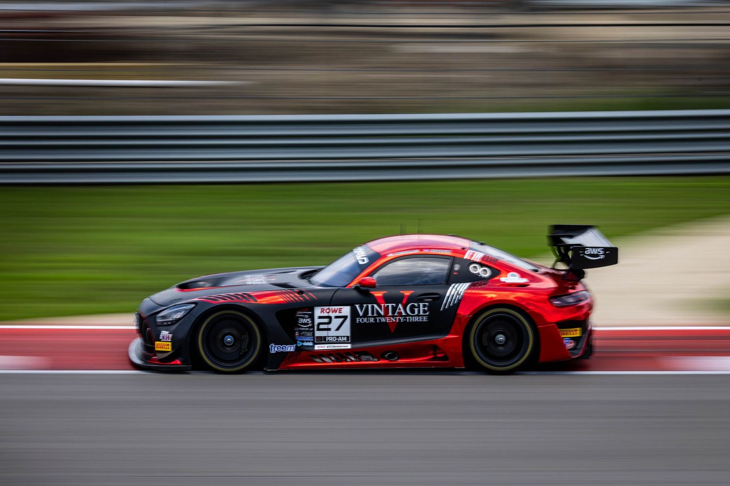 Red and black No. 27 Vintage GT3 race car speeding on a racing circuit.