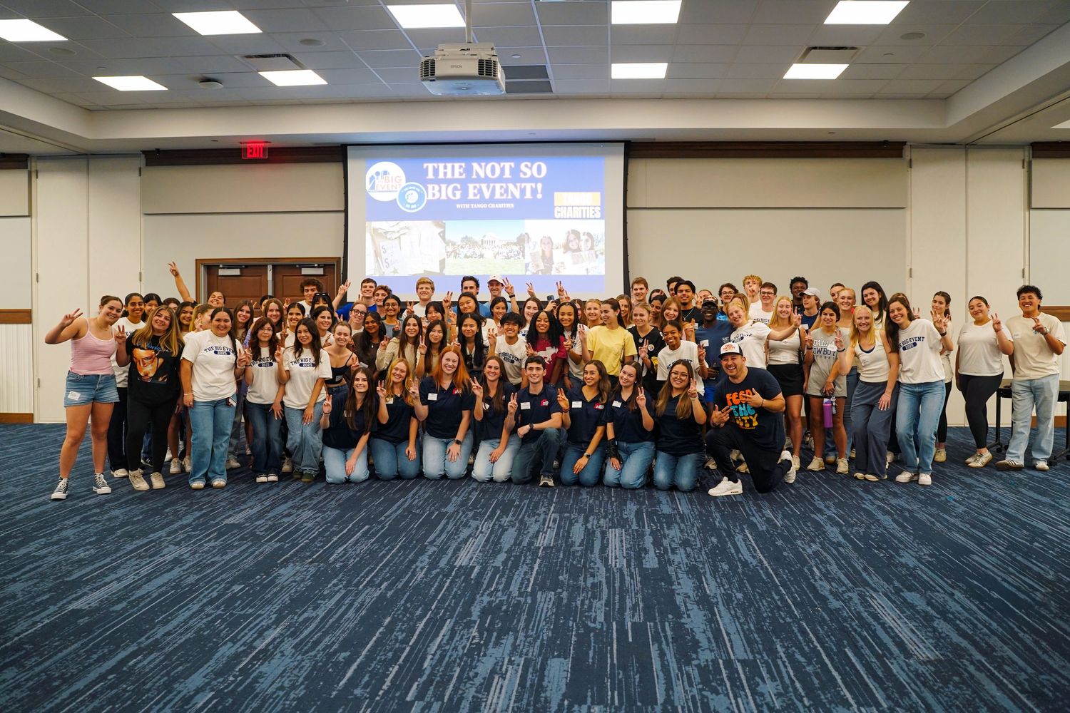 Large group of diverse college students posing together at The Not So Big Event in a university conference room.