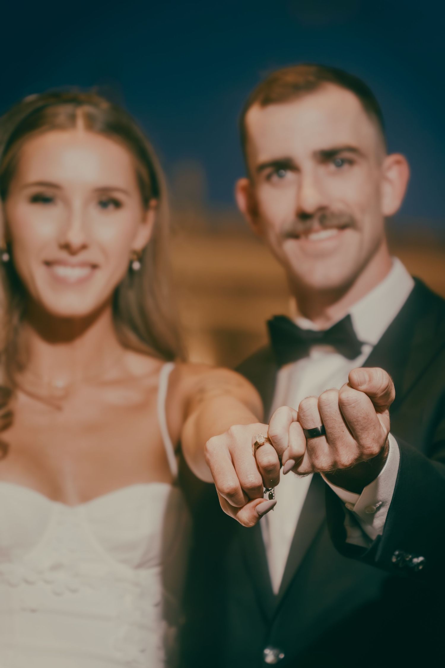 Smiling bride and groom displaying their linked wedding rings at their Las Vegas wedding.
