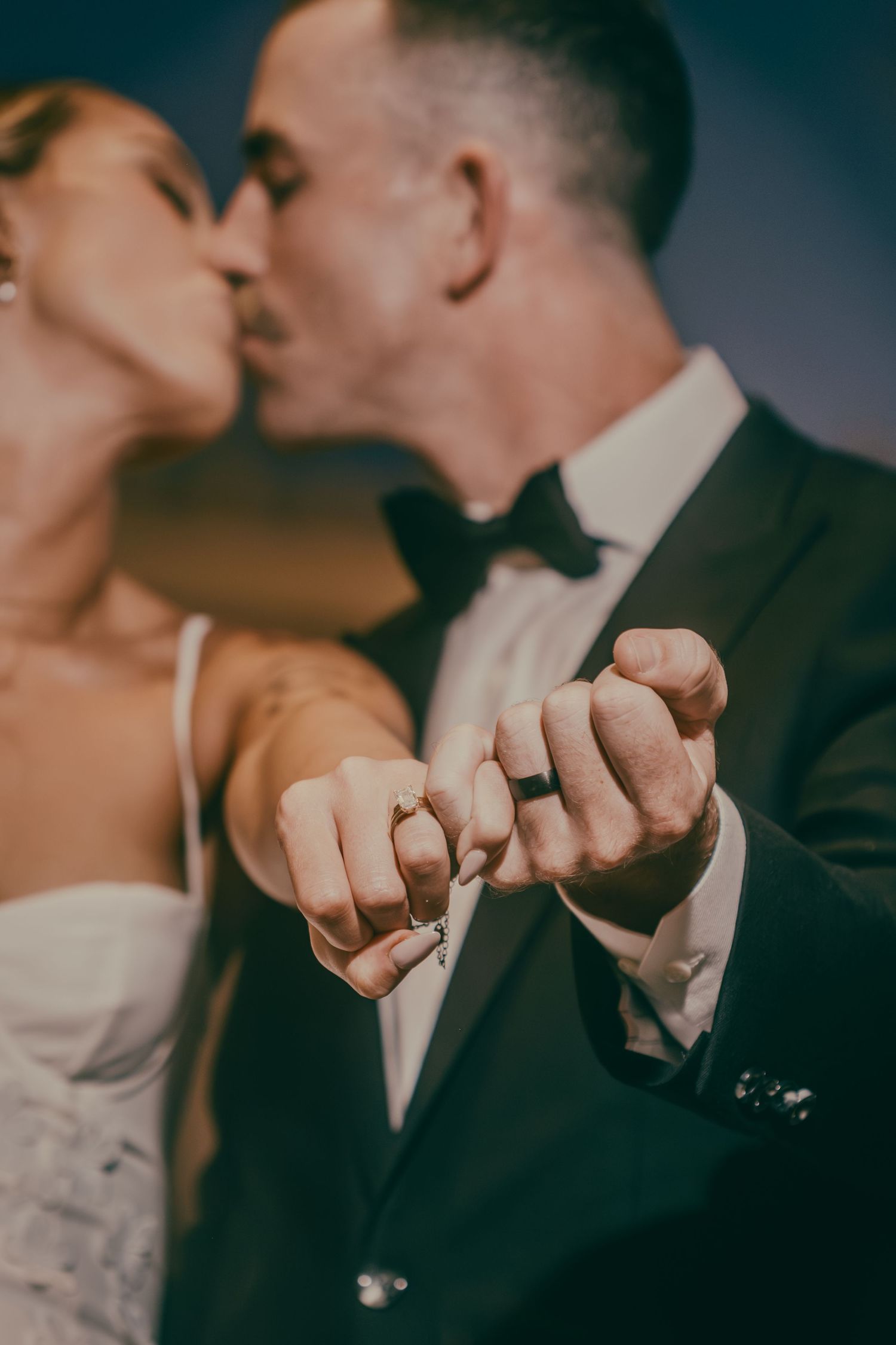 Newlyweds kissing while showing off their wedding rings linked together at their Las Vegas wedding.