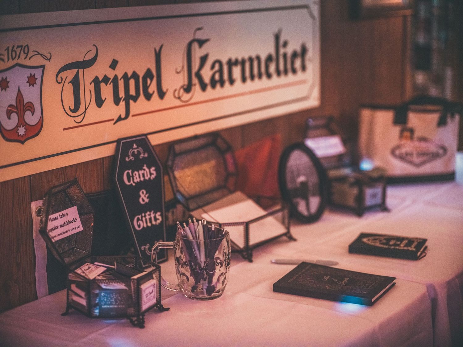 Tripel Karmeliet beer sign displayed above a wedding cards and gifts table with decorative items.