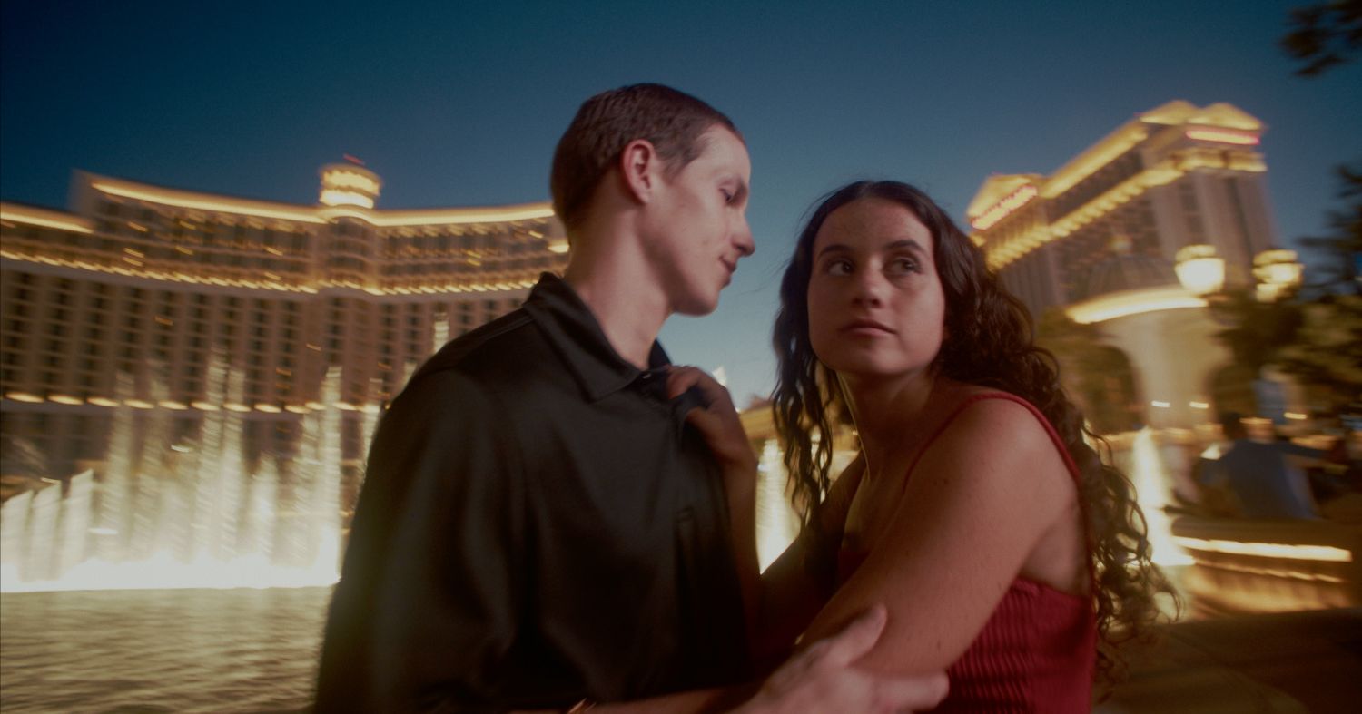 Romantic couple embracing at night in front of the illuminated Bellagio fountains in Las Vegas.