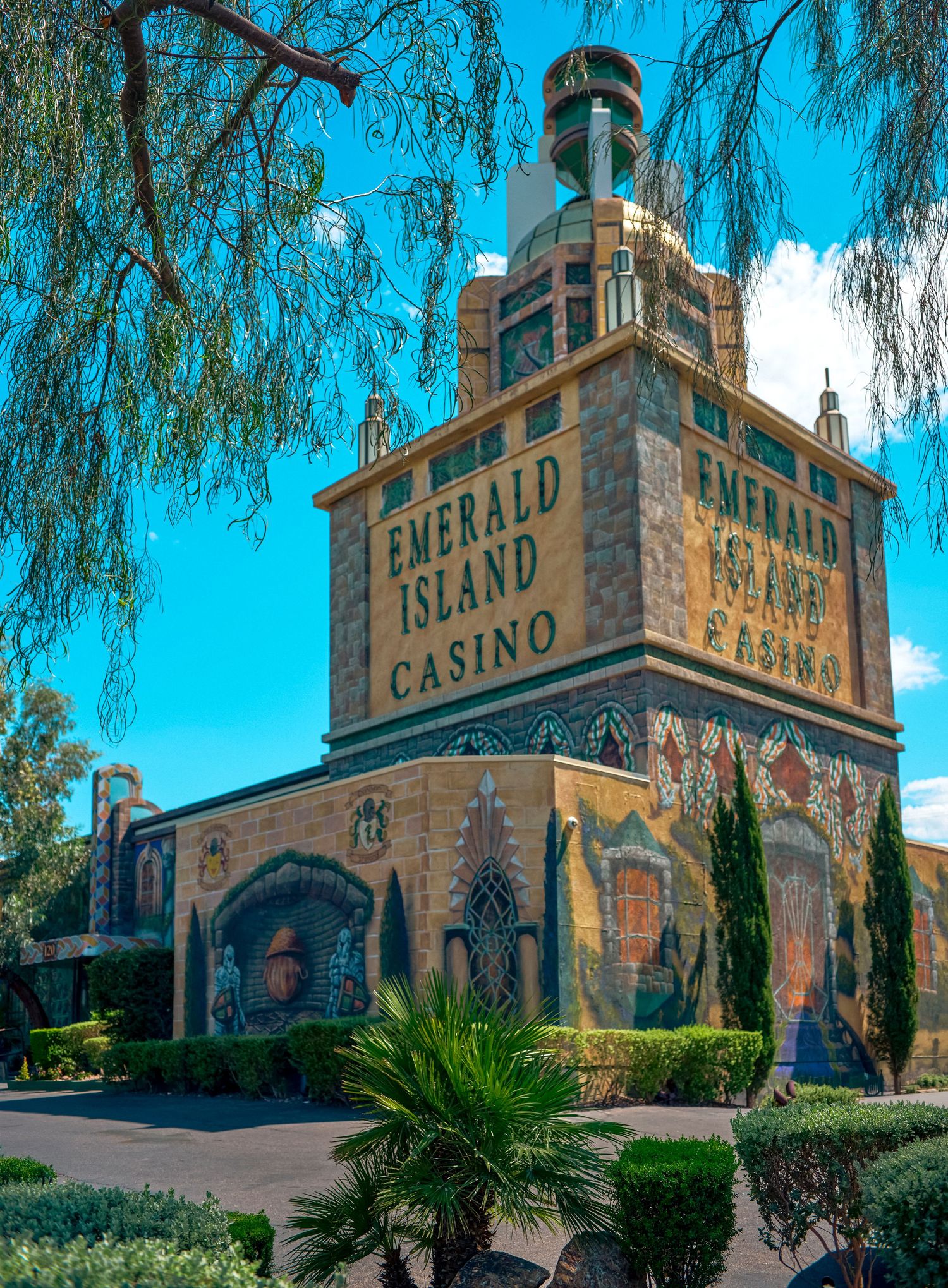 Emerald Island Casino building with vibrant mosaic murals and ornate architecture under a bright blue sky.