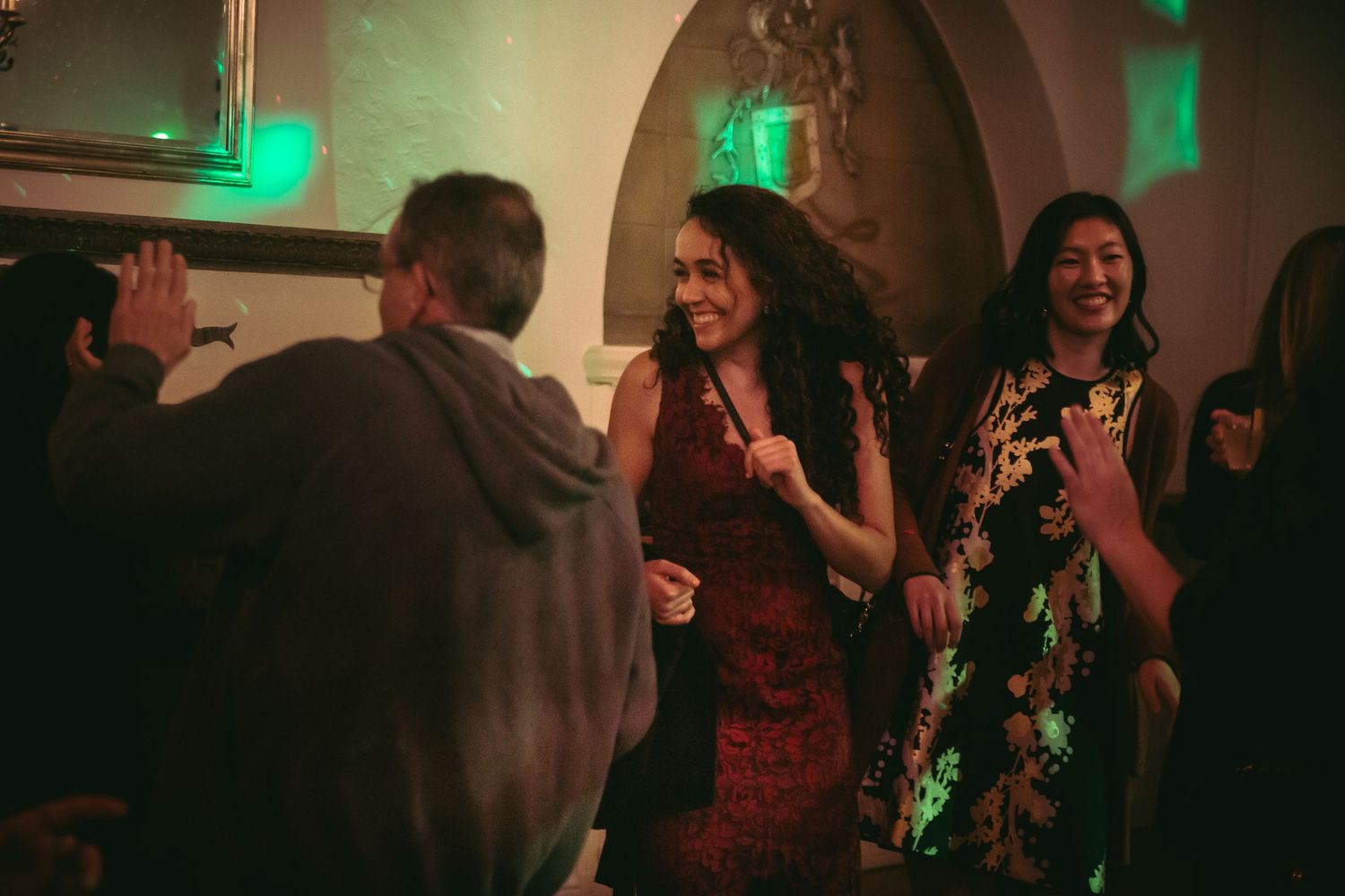Guests dancing and laughing together on the dance floor at a lively wedding reception.