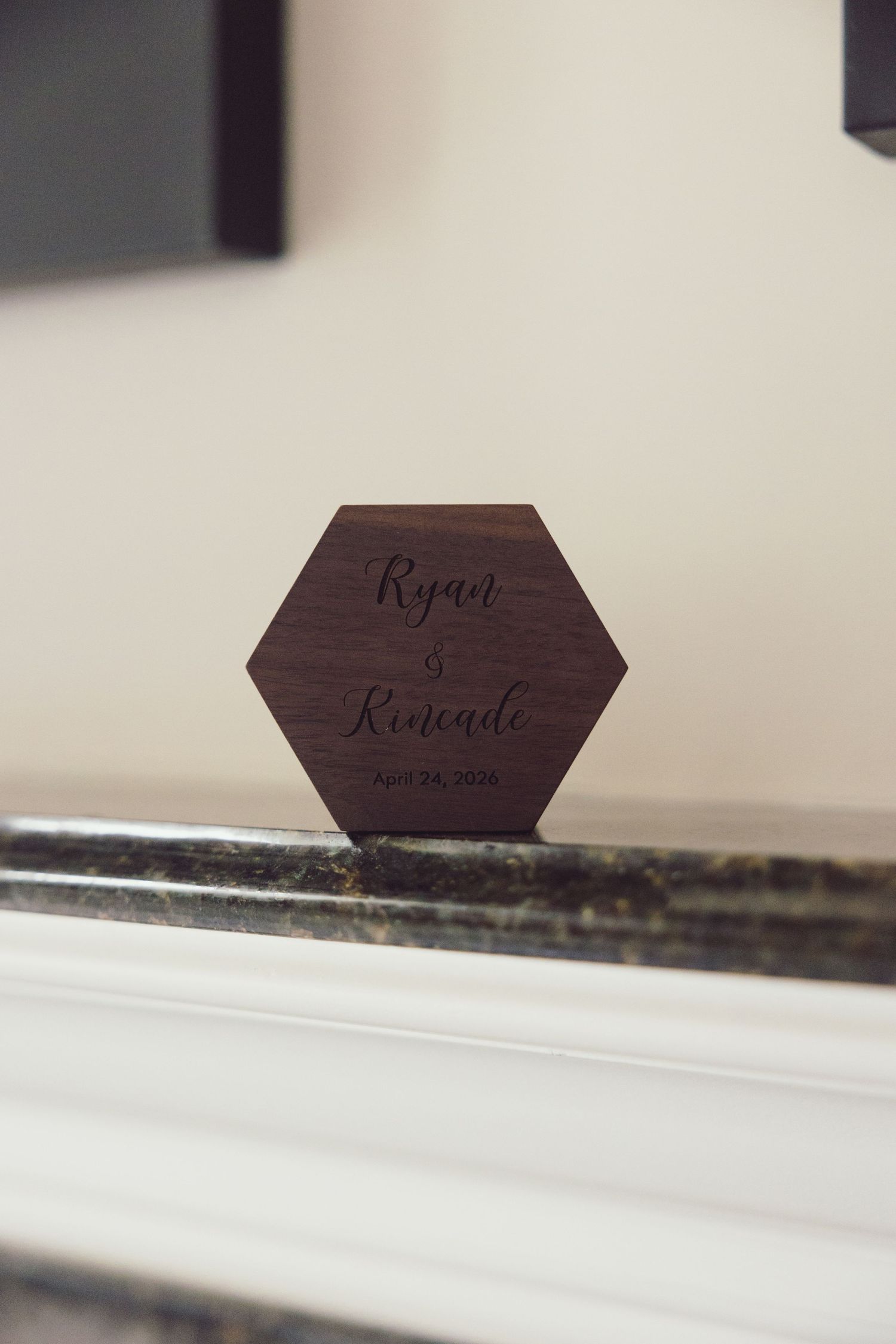 Hexagonal wooden wedding ring box engraved with Ryan and Kenzie April 2024.