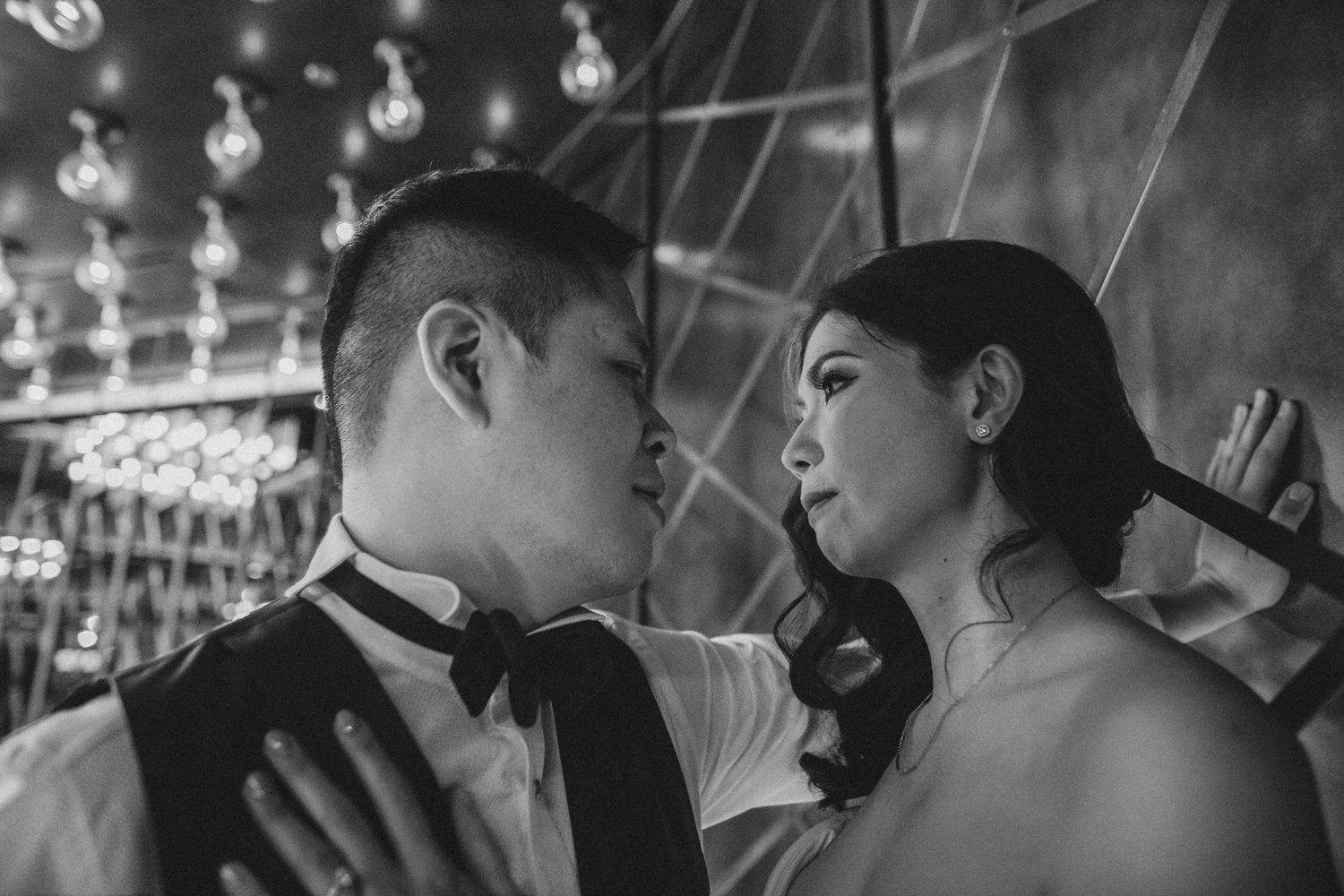 Bride and groom share an intimate moment during their first dance in a softly lit wedding venue.