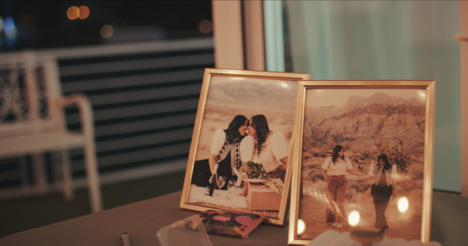 Framed wedding photos displayed on a table with candles at reception.