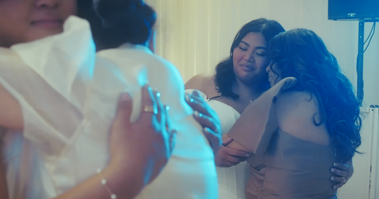 Guests sharing an emotional embrace during wedding reception celebration.