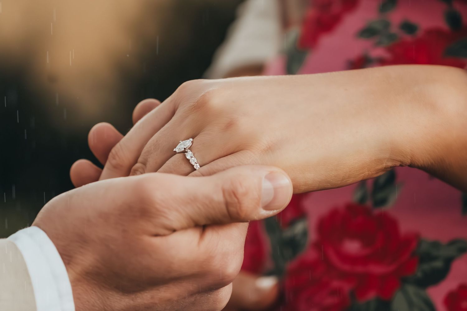 Close-up of a diamond engagement ring being placed on a woman's finger during a proposal.