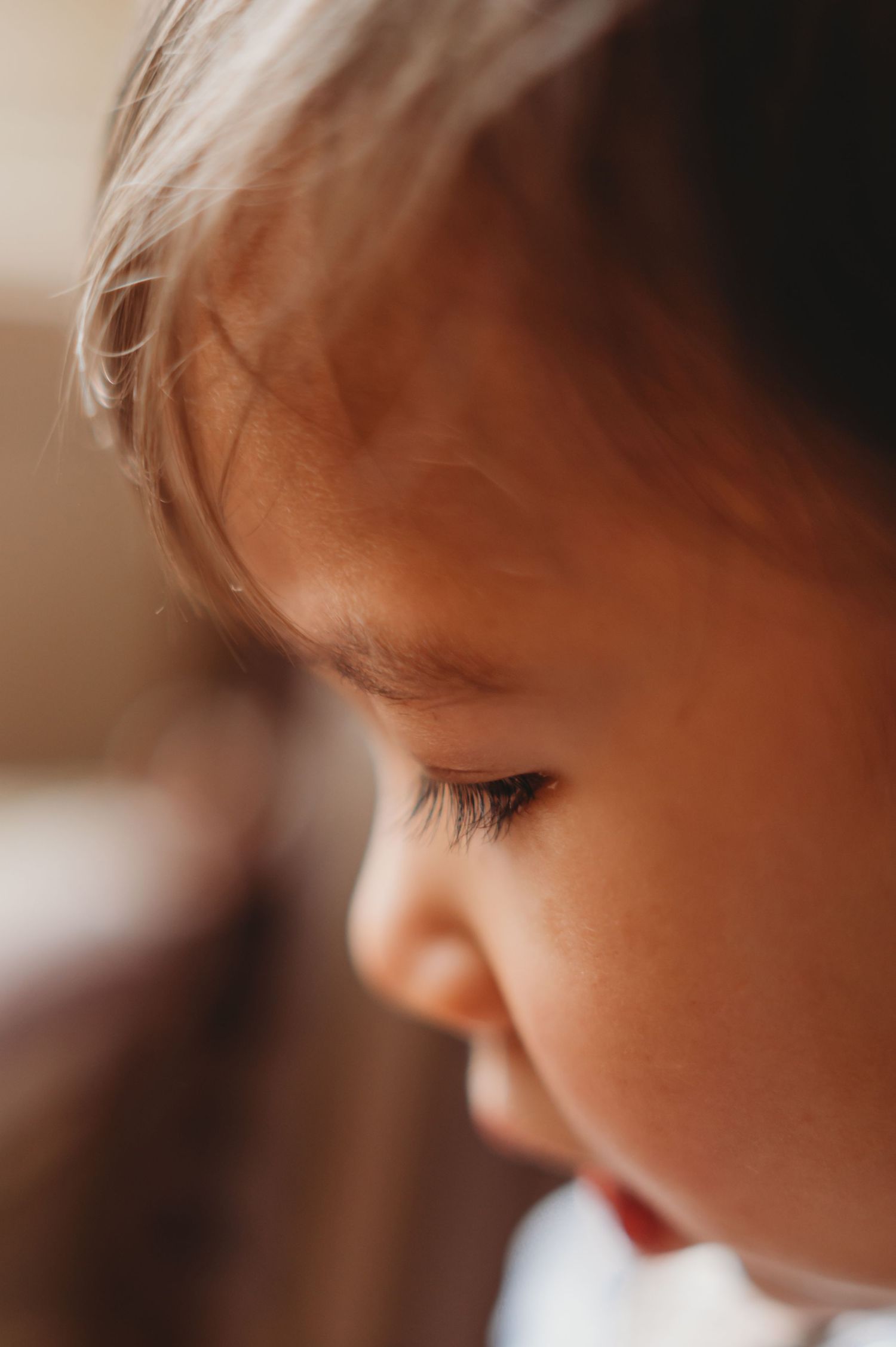 Soft close-up portrait of a young toddler's face with delicate features and long lashes.