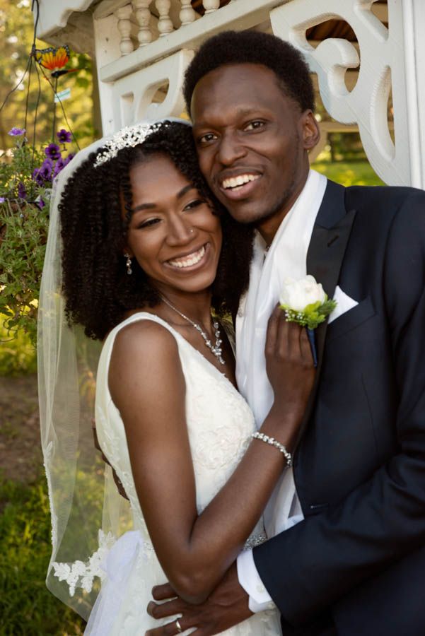 Bride and groom smiling together during outdoor wedding portrait