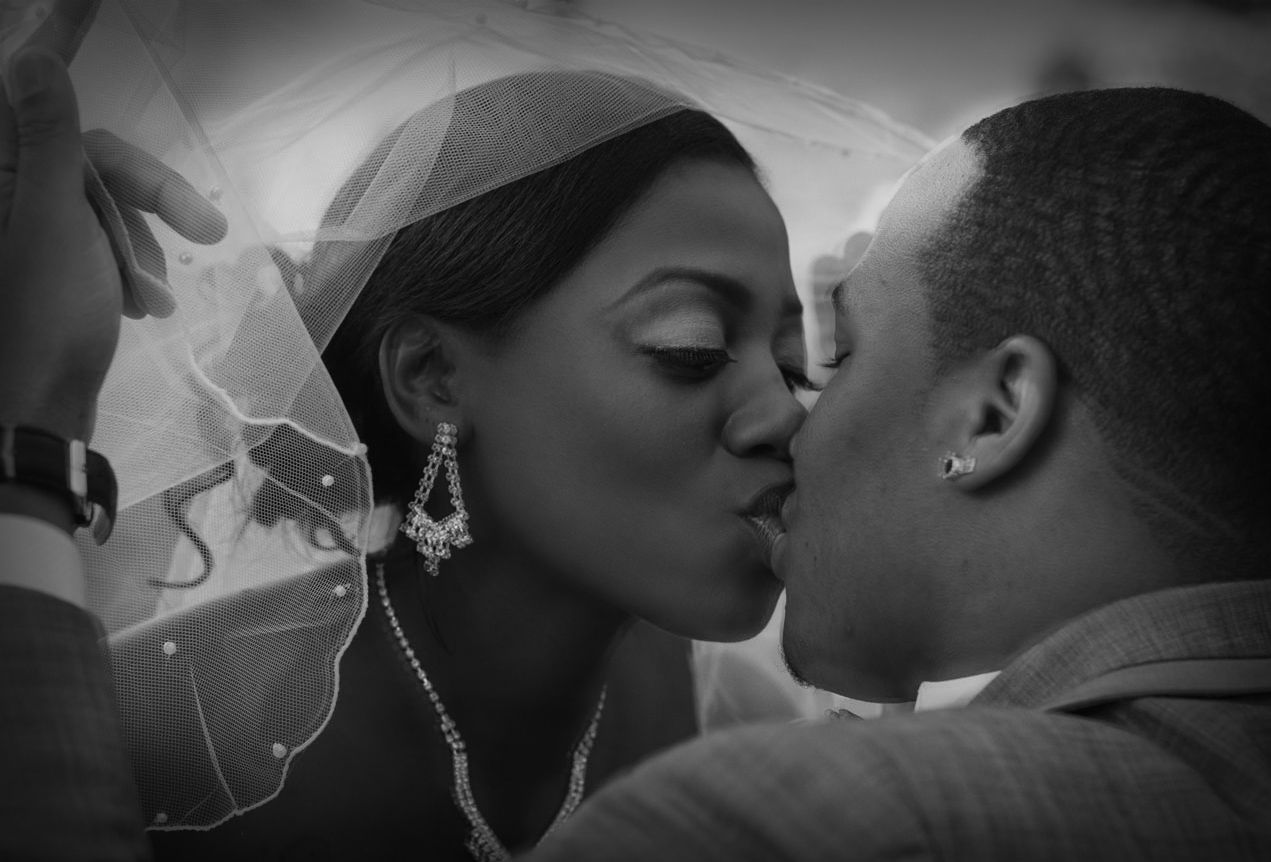 Black and white close-up of bride and groom sharing a romantic wedding kiss
