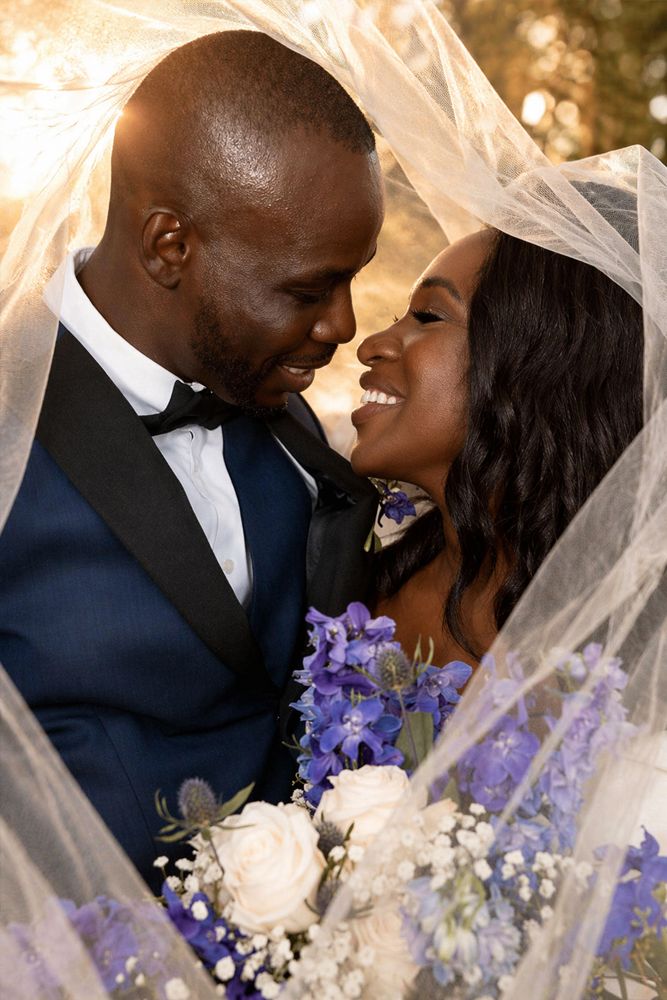 Close-up of bride and groom sharing a kiss under the veil during wedding