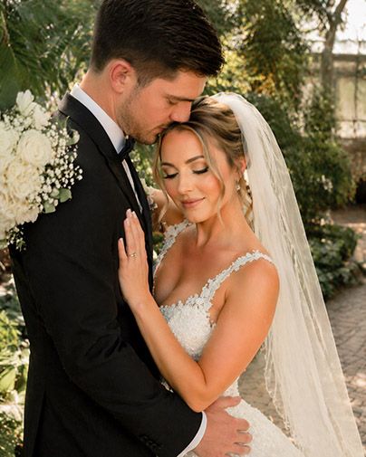 Bride and groom embracing closely during romantic wedding portrait session