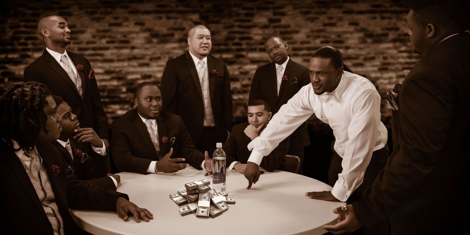 Groomsmen group laughing and preparing together before wedding