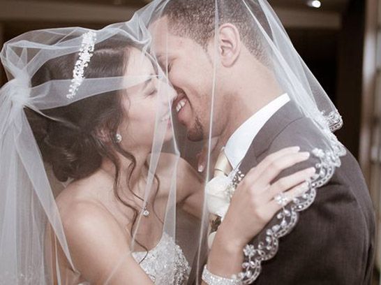 Bride and groom kissing under the veil during intimate wedding moment