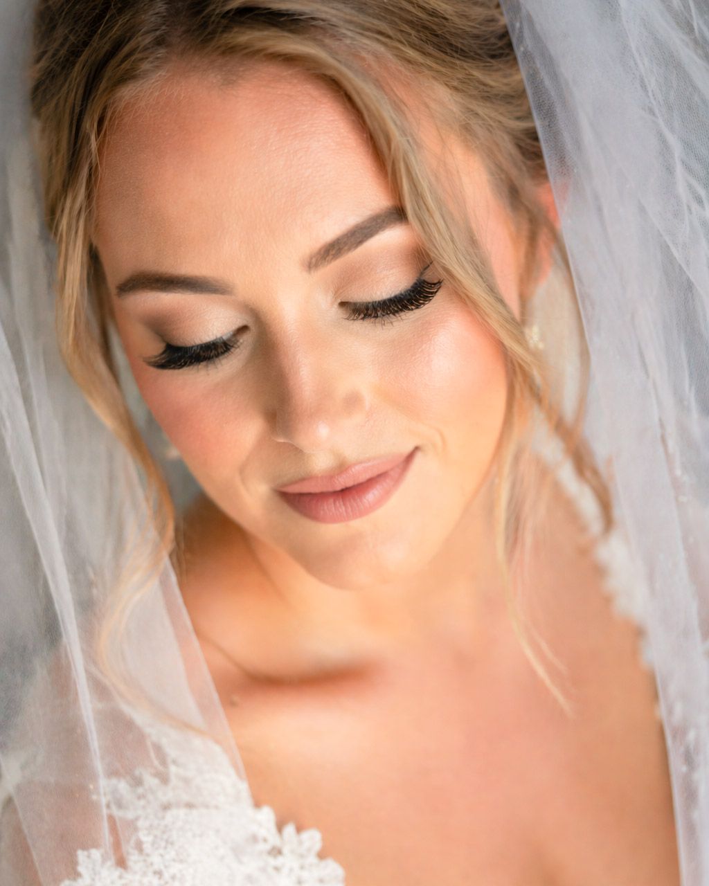 Soft bridal portrait with natural makeup and gentle lighting highlighting bride’s expression