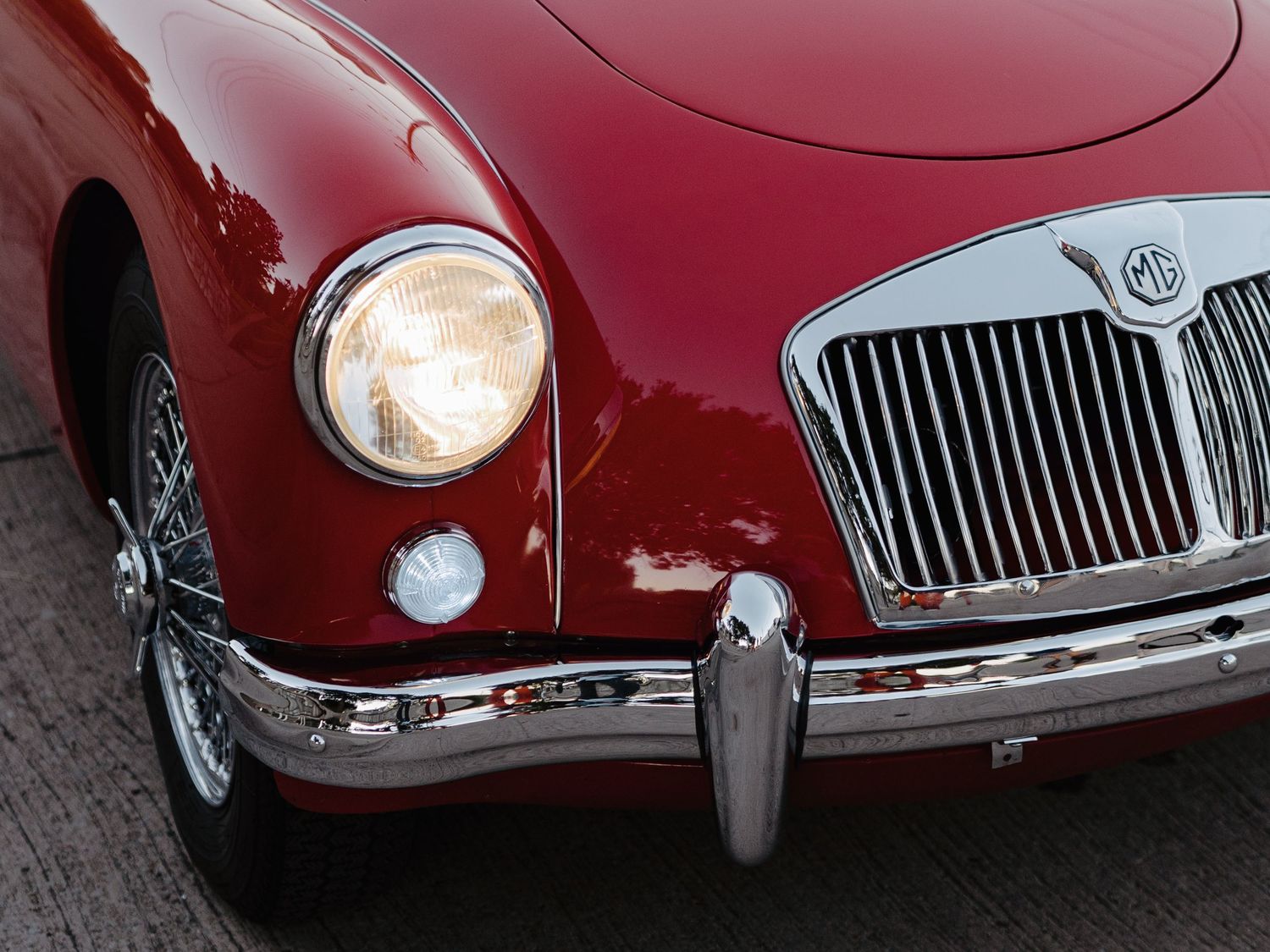 Close-up front detail of classic red MGA vintage sports car with chrome grille.