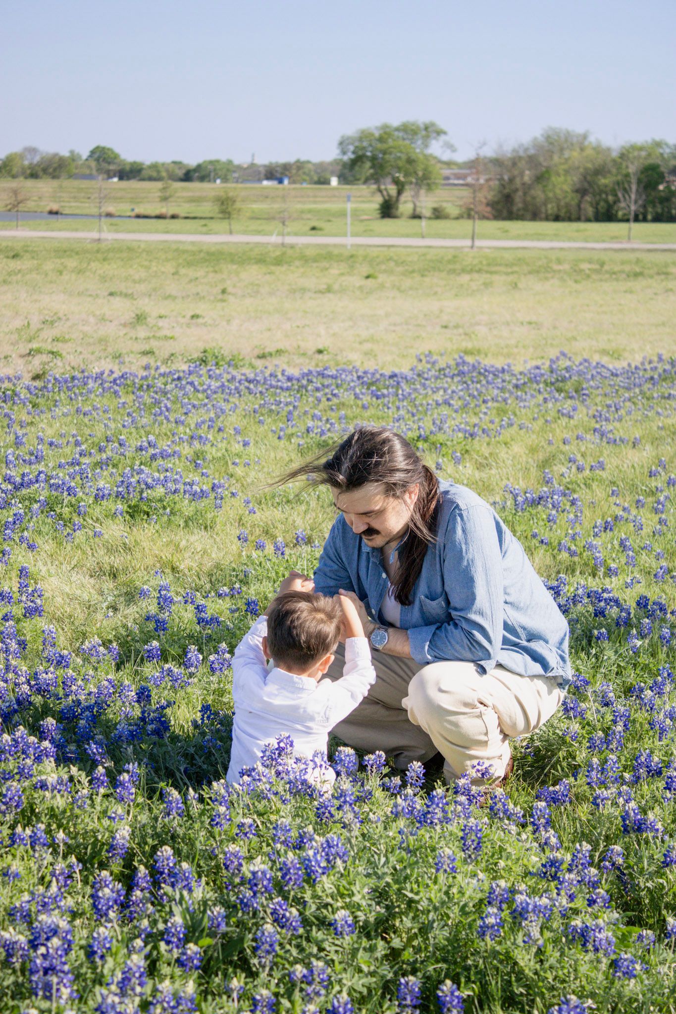 Mother and child bonding in a vibrant Texas bluebonnet field on a sunny spring day.