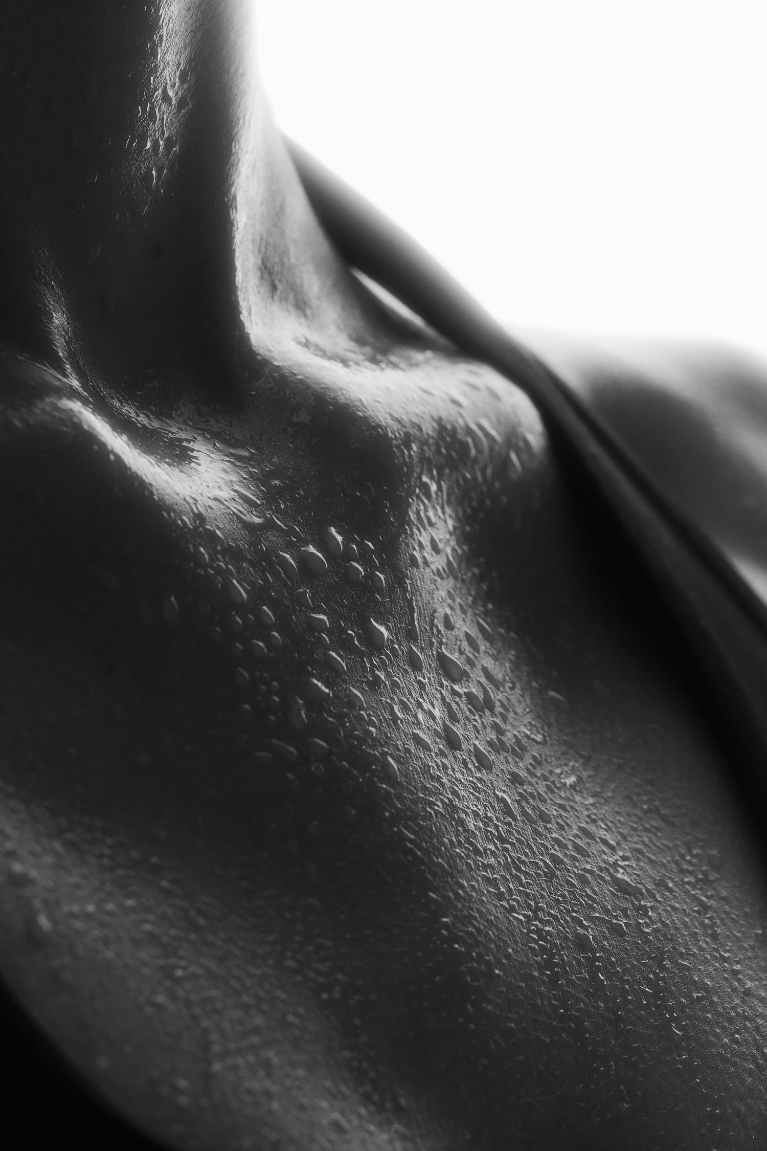 Extreme close-up black and white image of sweat droplets on athletic skin.