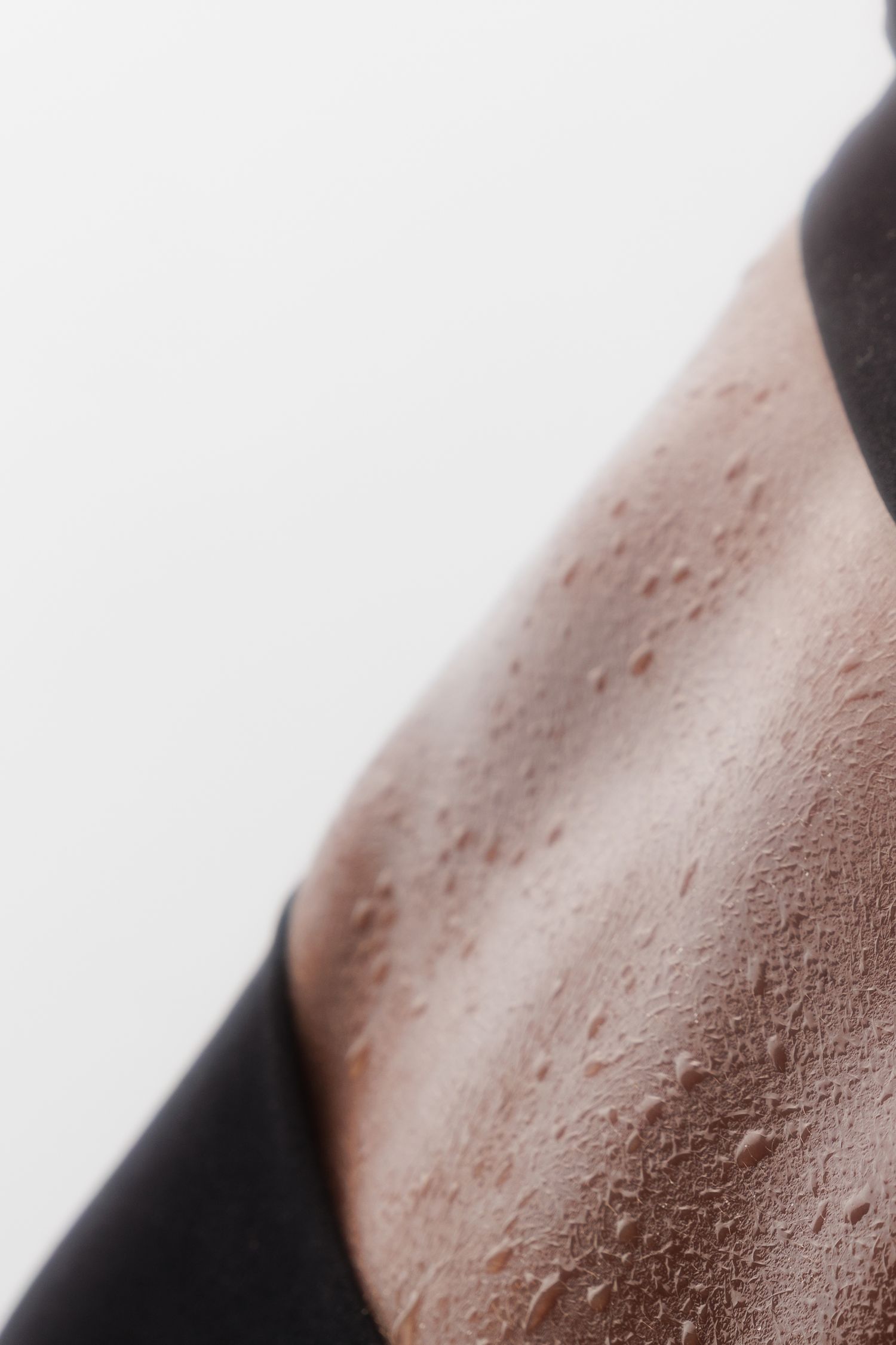 Close-up of sweaty skin texture on a person's torso during workout.
