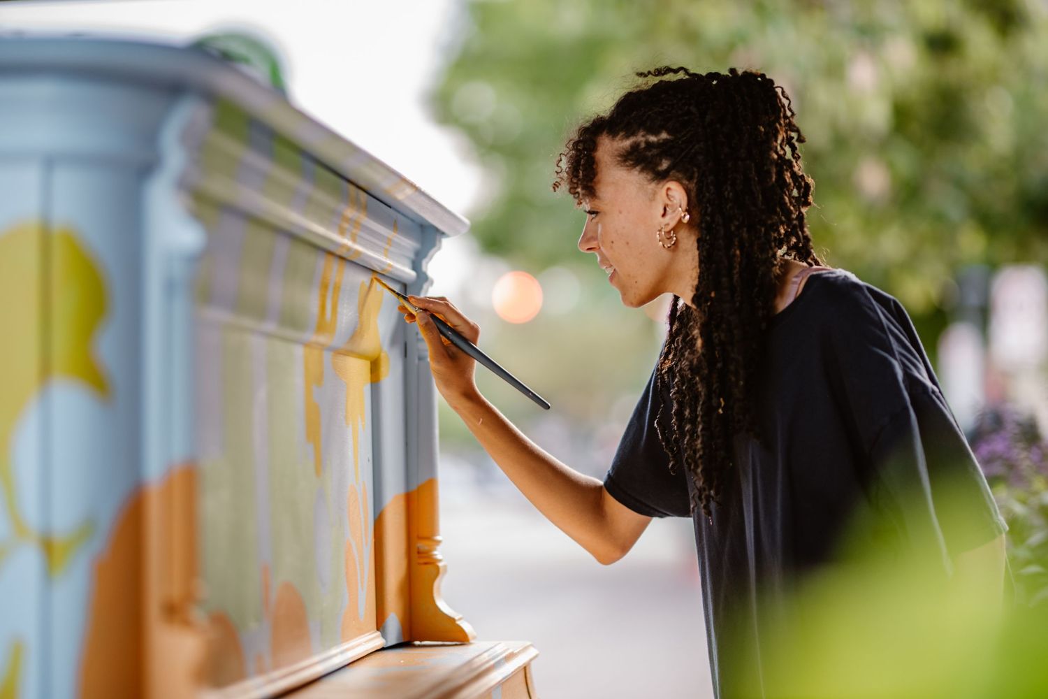 Side view of someone painting on a colorful outdoor surface.