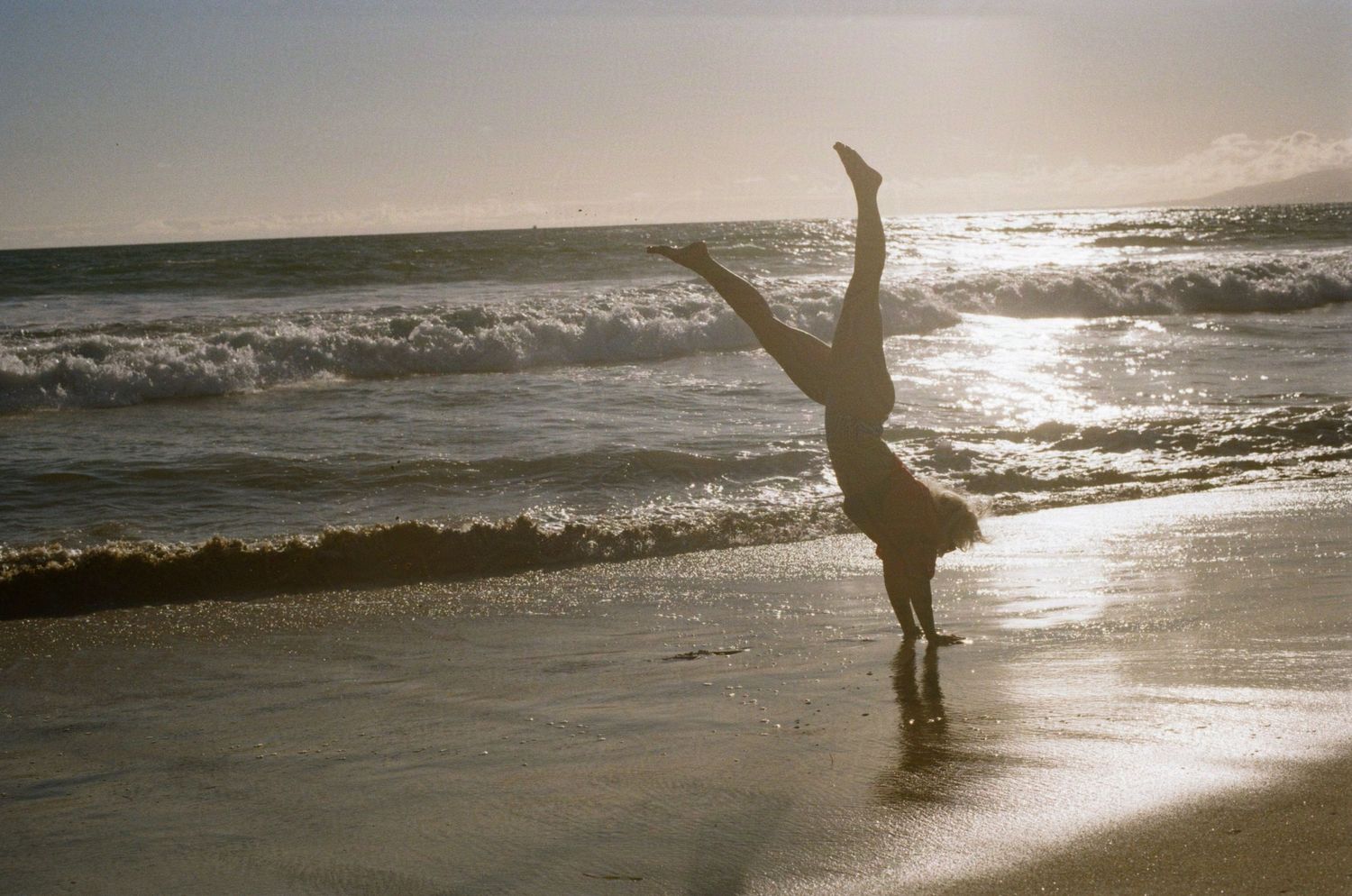 Parisian burlesque performer Djerry Can does a beach handstand in front of a sunset. (Santa Monica Pier)

35mm film photo
© snapnon 2026