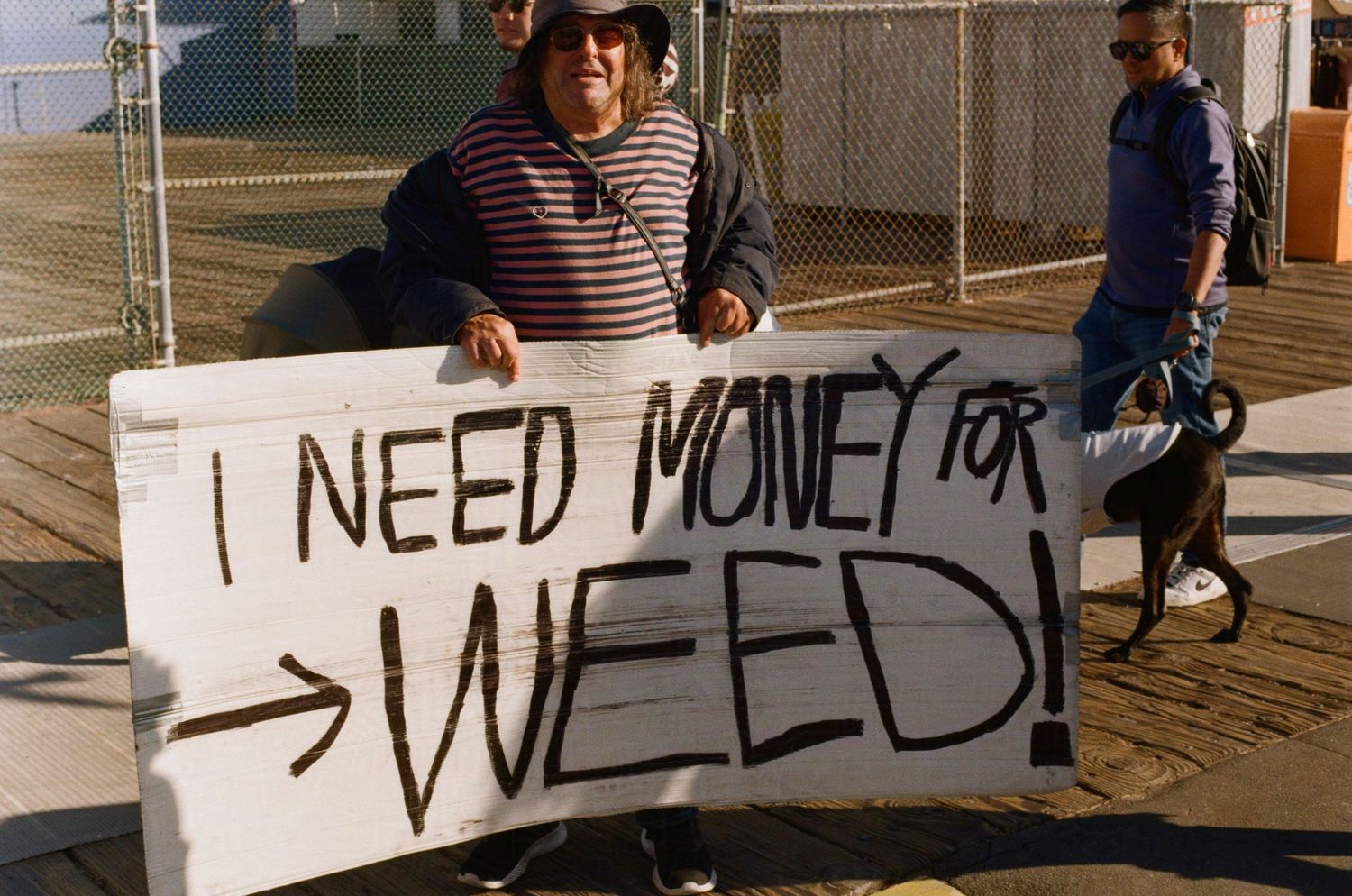 Street photography of a man with a large sign that says 