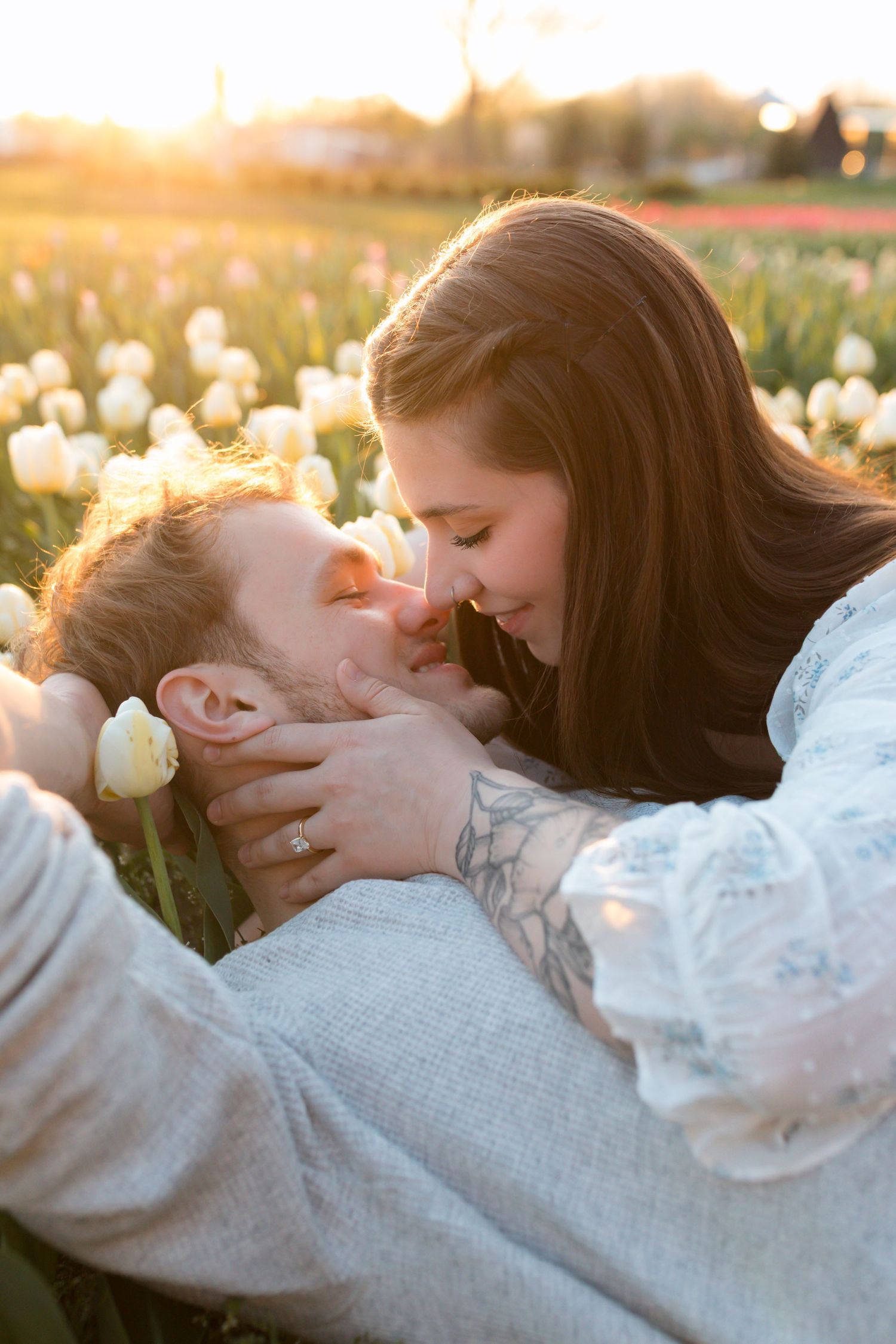Couple kissing in tulip field.